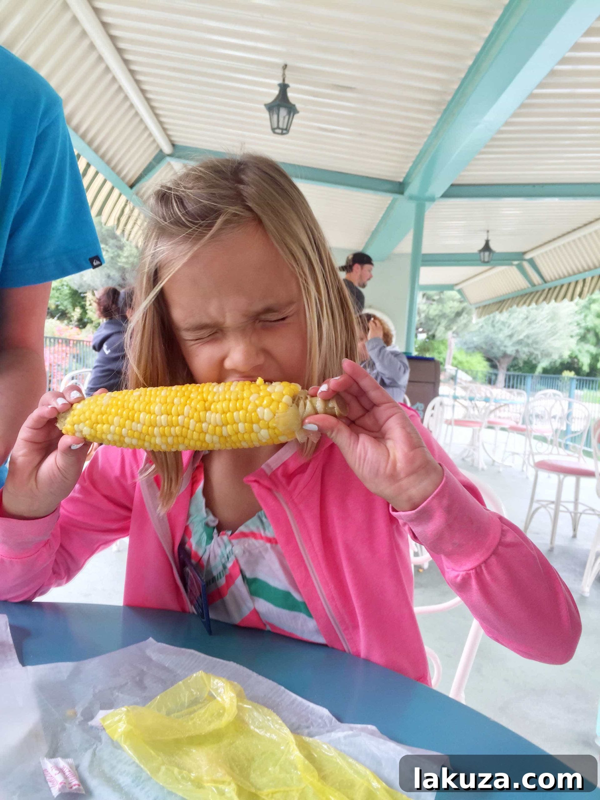 Disneyland's Gastronomic Gold: Essential Eats & Sweet Treats 8 A sweet, buttery corn on the cob at Disneyland, a simple yet beloved treat perfect for a quick snack between attractions.