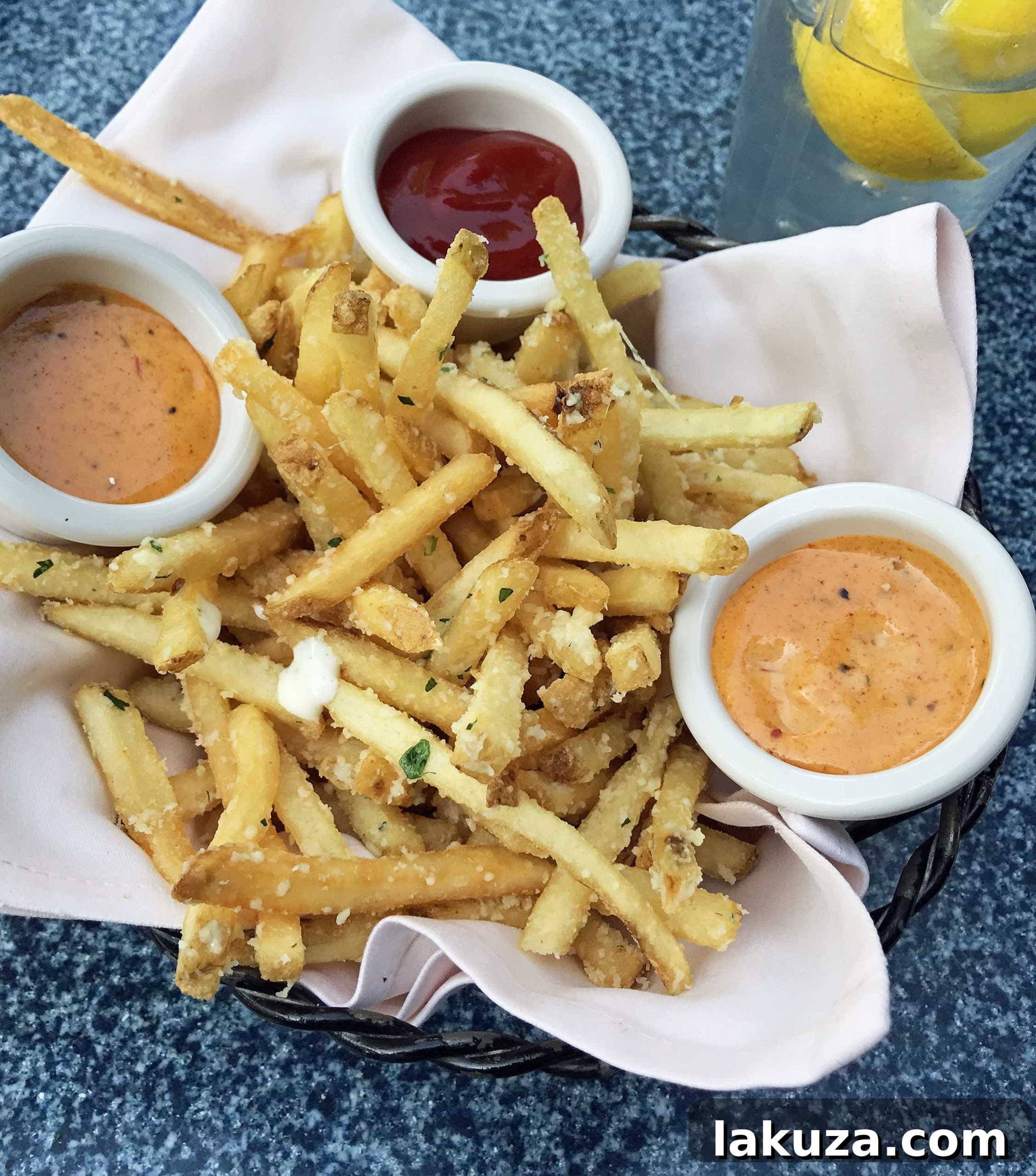 Disneyland's Gastronomic Gold: Essential Eats & Sweet Treats 6 Delicious Pommes Frites at Cafe Orleans in Disneyland, tossed with parmesan, garlic, and parsley, served with a unique Cajun spice rémoulade.