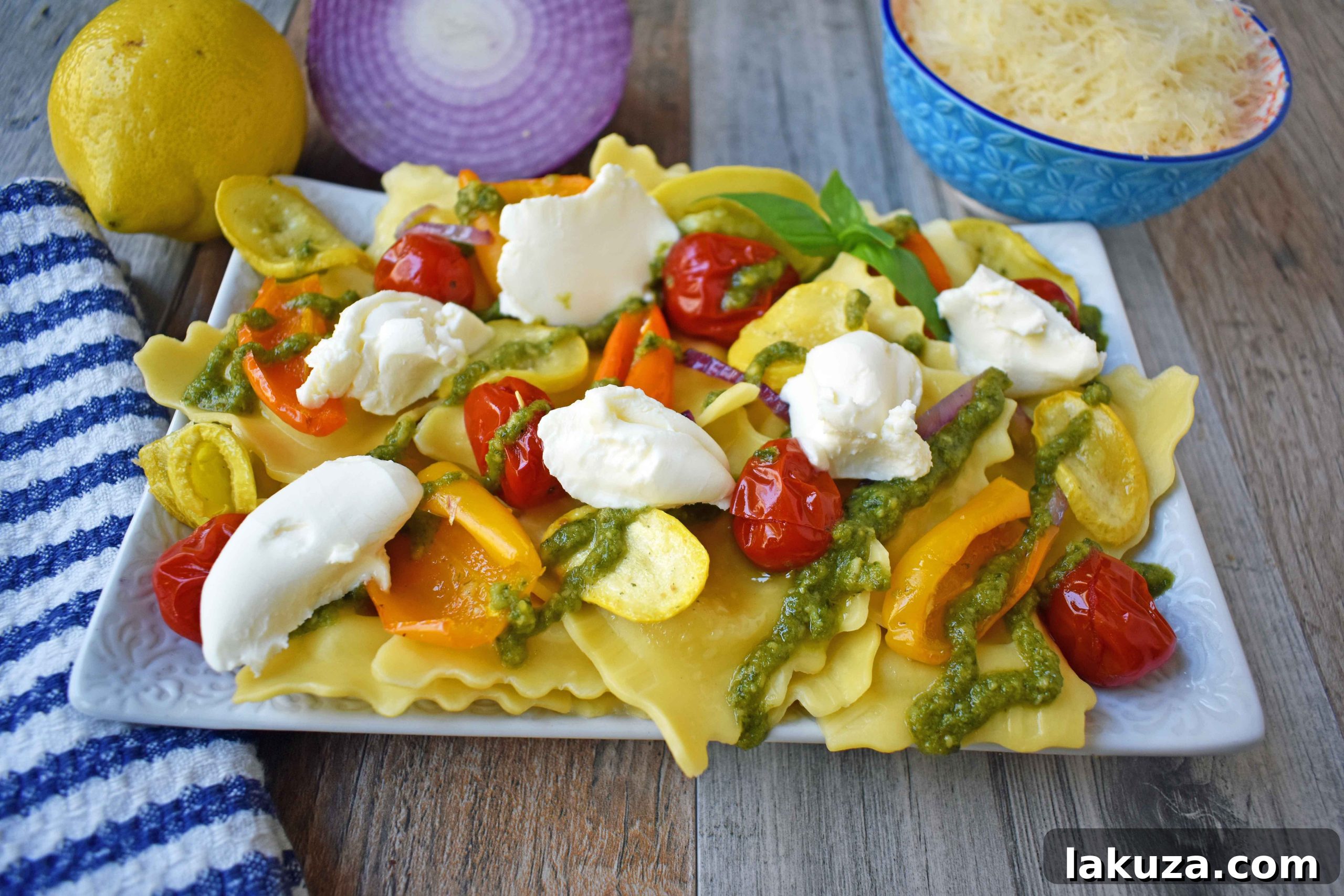 Summer Roasted Vegetable Pesto Ravioli with Mascarpone - A complete dish featuring fresh cheese ravioli, colorful roasted vegetables, basil pesto, and creamy dollops of mascarpone cheese, garnished with fresh basil.