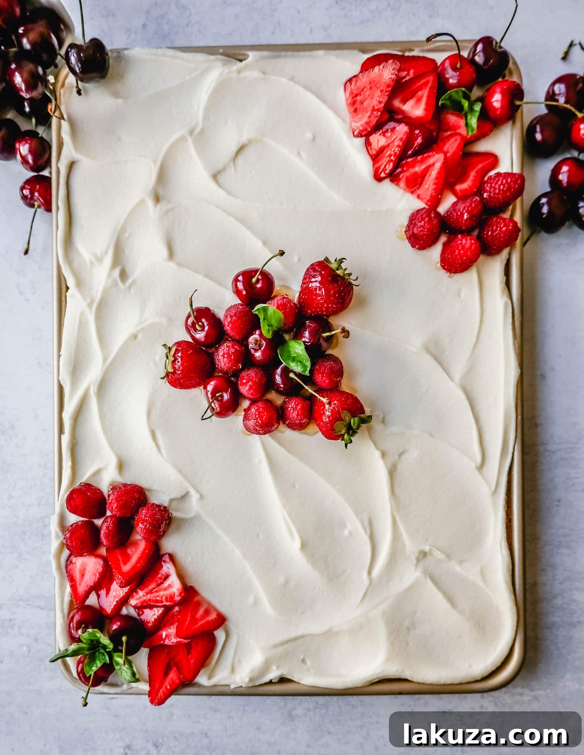 Southern Charm Vanilla Sheet Cake 4 A slice of White Texas Sheet Cake topped with fresh raspberries and blueberries, showcasing the vibrant colors.