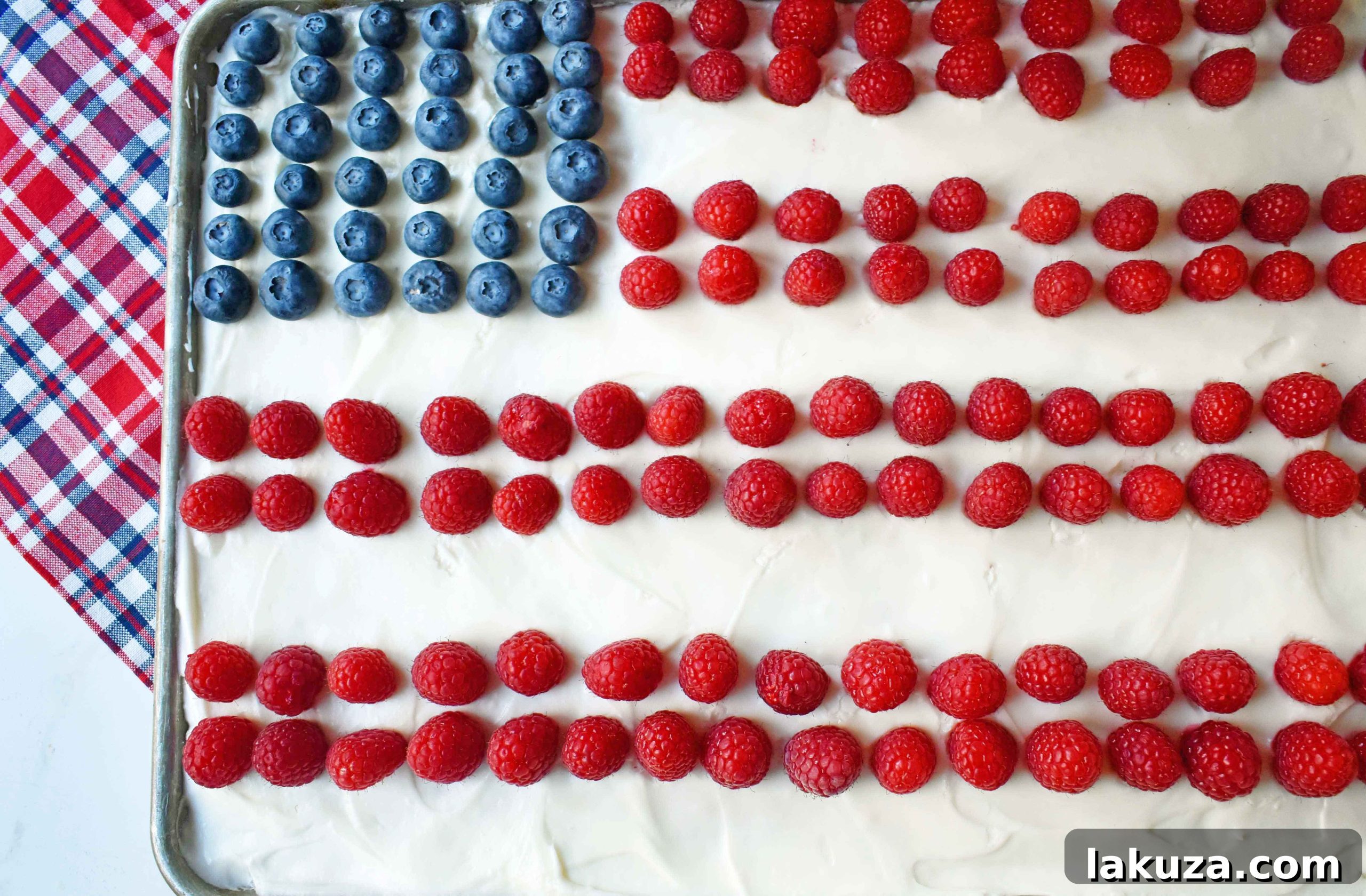 Southern Charm Vanilla Sheet Cake 5 Vanilla Almond White Texas Sheet Cake decorated as a festive flag for the 4th of July with fresh raspberries and blueberries on a white cream cheese frosting.