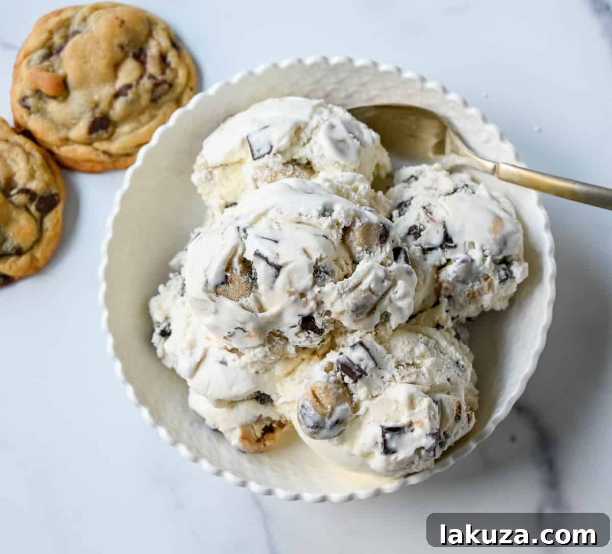 Close-up of creamy vanilla ice cream with visible chocolate chip cookie dough chunks.