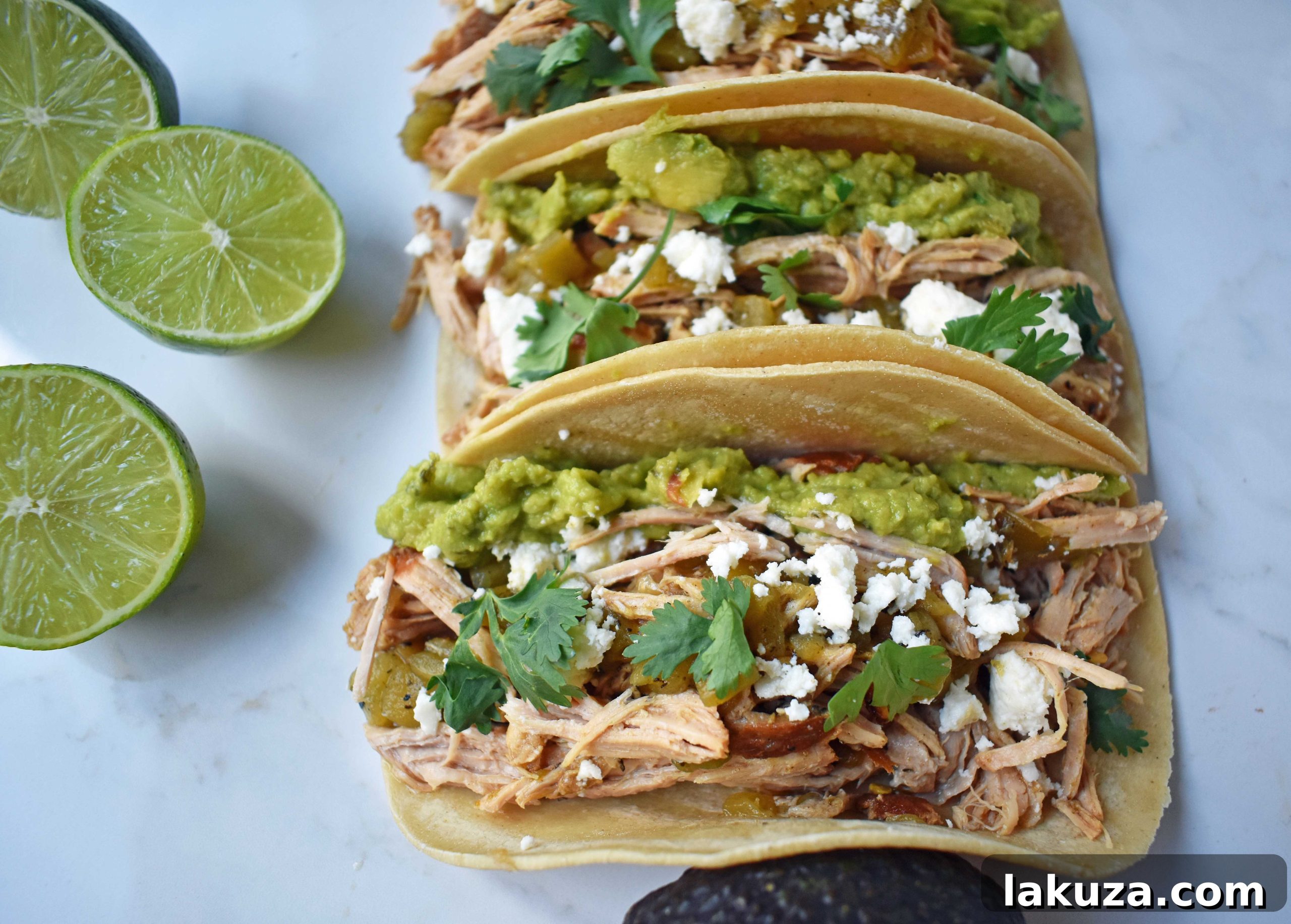 An array of Green Chili Pork Carnitas Tacos, freshly prepared and garnished with authentic Mexican toppings, inviting you to indulge in a flavorful culinary experience.