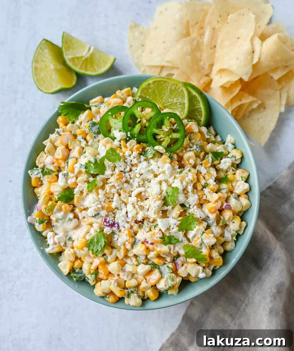 Creamy Elote Dip 3 A close-up of a bowl of Mexican Street Corn Dip, highlighting the roasted corn, vibrant red onion, fresh cilantro, and creamy dressing, ready to be served.