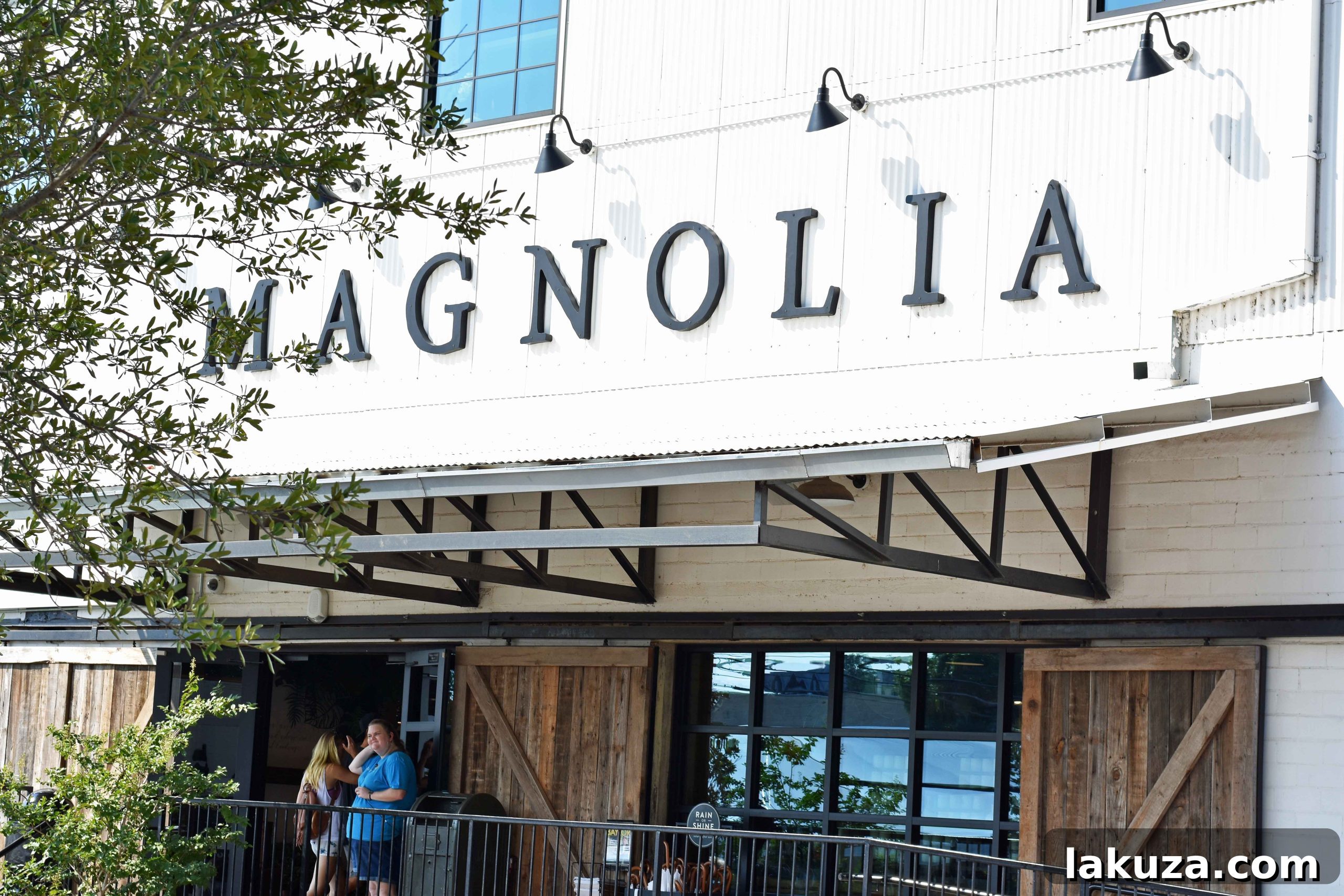 Lush green lawn and market buildings at Magnolia Market, inviting visitors to explore