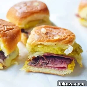 Hot Pastrami and Swiss Tailgate Sliders. Pastrami, creamy swiss, tangy mustard all on a hawaiian roll basted with garlic butter and baked until warm and toasty. A flavorful hot pastrami sandwich that is so easy! Perfect for entertaining, watching a football game, or a dinner at home.