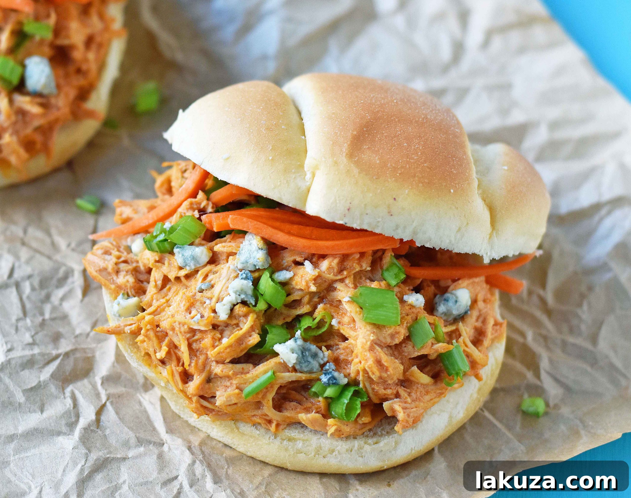 Zesty Creamy Slow Cooker Buffalo Ranch Chicken 4 Serving suggestion for Buffalo Ranch Chicken: classic sliders on brioche buns, garnished with fresh blue cheese crumbles and crisp matchstick carrots. This image showcases the ultimate comfort food for any gathering or casual dinner.
