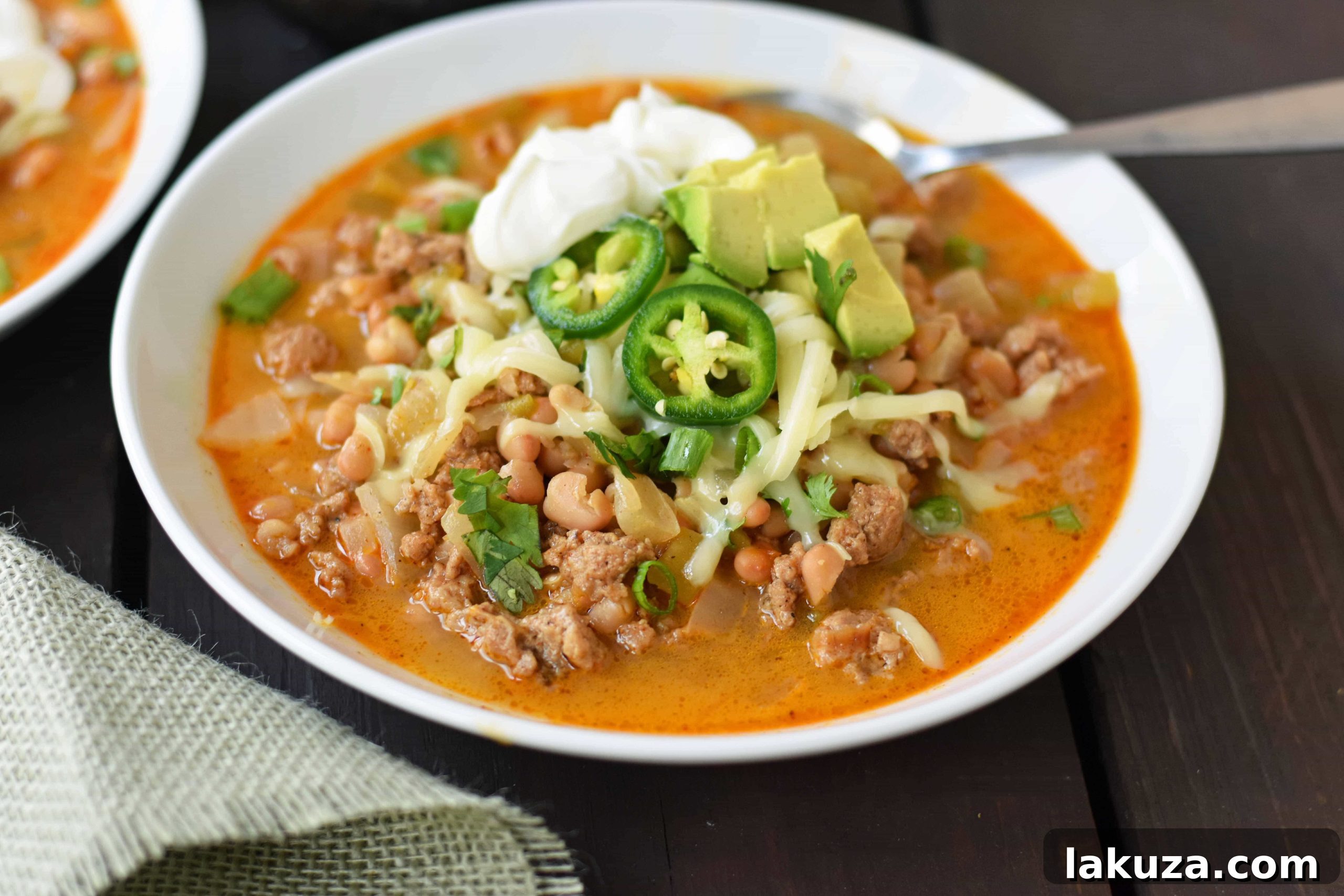 Close-up of a bowl of White Bean Turkey Chili, showcasing its rich texture and colorful toppings, perfect for a quick and healthy dinner.