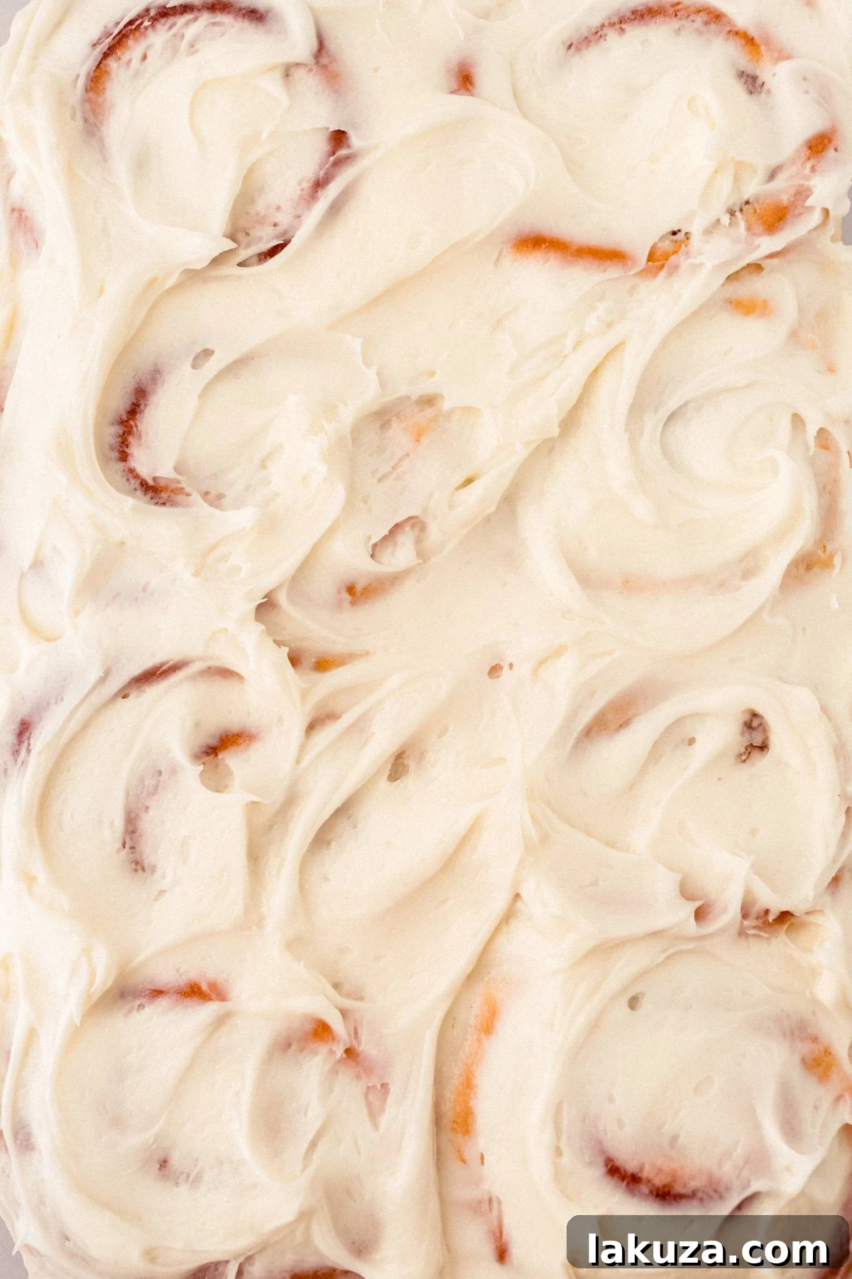 Heavenly Homemade Cinnamon Buns 13 Close-up of a frosted homemade cinnamon roll with generous cream cheese frosting, showing the rich texture and delicious appeal of the final product.