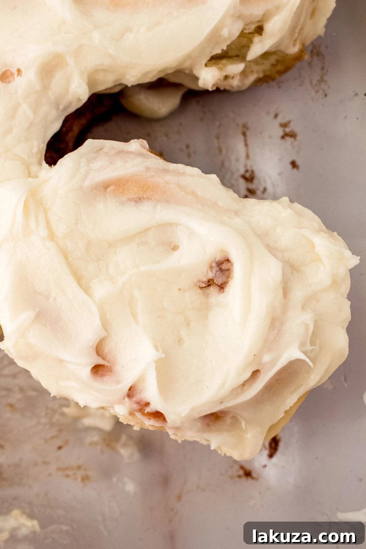 Heavenly Homemade Cinnamon Buns 16 A close-up of a perfectly baked Hayley's Famous Cinnamon Roll, featuring its golden-brown exterior and visible spirals of cinnamon sugar filling, ready for frosting.