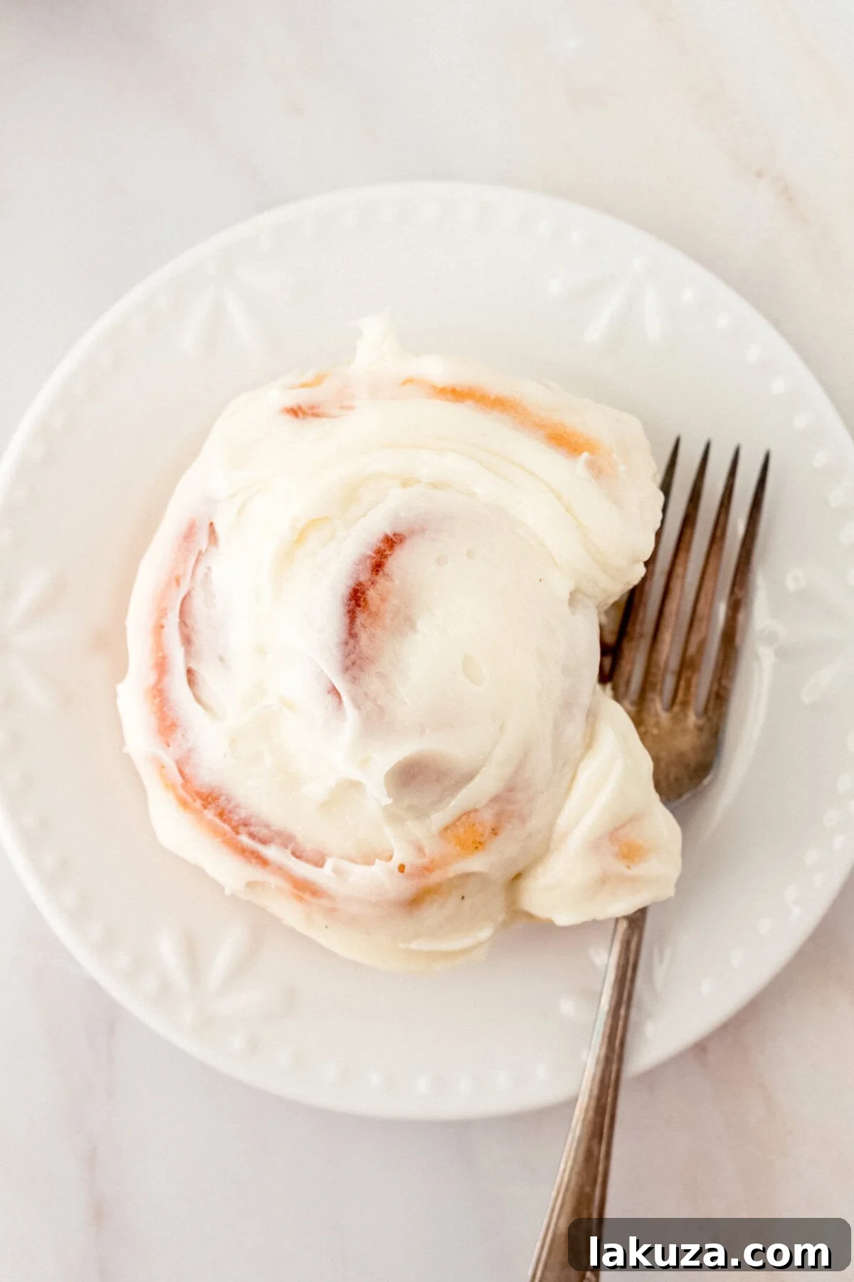 Heavenly Homemade Cinnamon Buns 17 A freshly baked and generously frosted Hayley's Famous Cinnamon Roll, showcasing the thick layer of cream cheese icing melting slightly into the warm, soft roll.