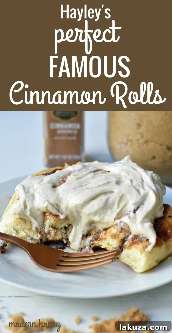 Heavenly Homemade Cinnamon Buns 22 Two Hayley's Famous Cinnamon Rolls, beautifully frosted with cream cheese icing, on a rustic wooden board, ready to be enjoyed.