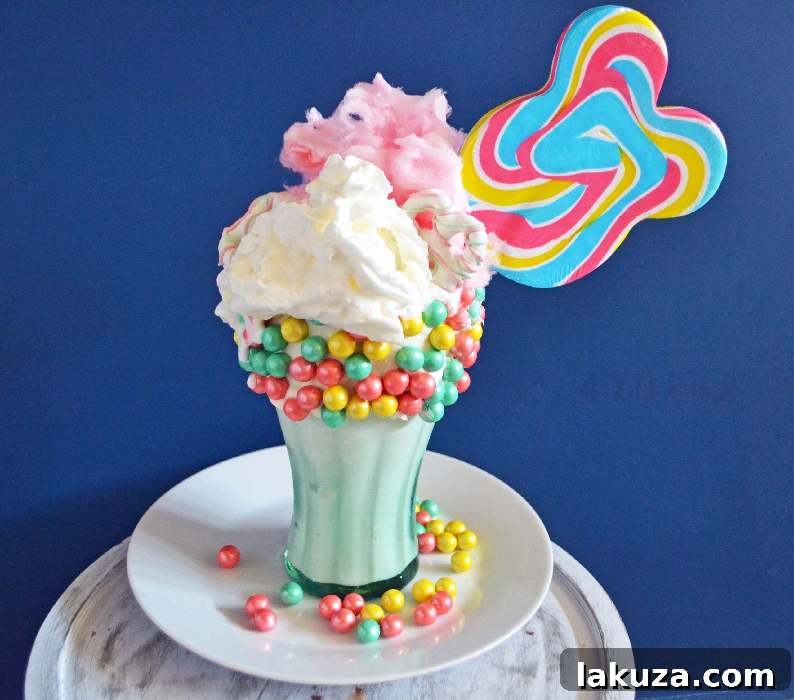 Recreate Black Tap's Jaw-Dropping Milkshakes 3 Homemade Black Tap Milkshake: A 'Cotton Candy Sugar Bomb' copycat, featuring a creamy vanilla ice cream base, colorful Sixlet pastel pearls, airy cotton candy, crisp white chocolate pretzels, a sweet lollipop, and a lavish topping of whipped cream.