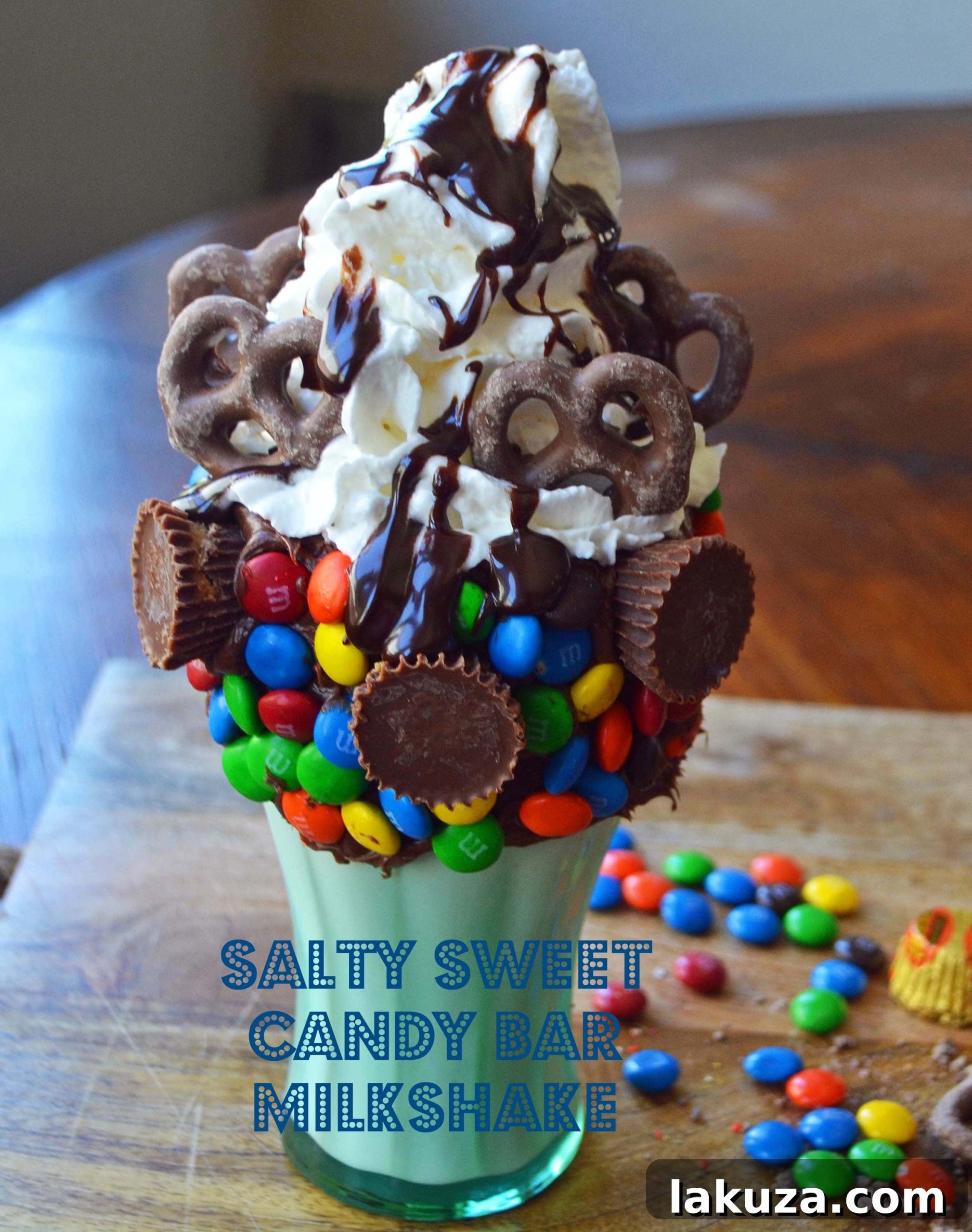 Recreate Black Tap's Jaw-Dropping Milkshakes 9 Black Tap Salty Sweet Candy Bar Milkshake copycat, featuring vanilla ice cream, M&M's, peanut butter cups, chocolate covered pretzels, hot fudge, and whipped cream, by Modern Honey.
