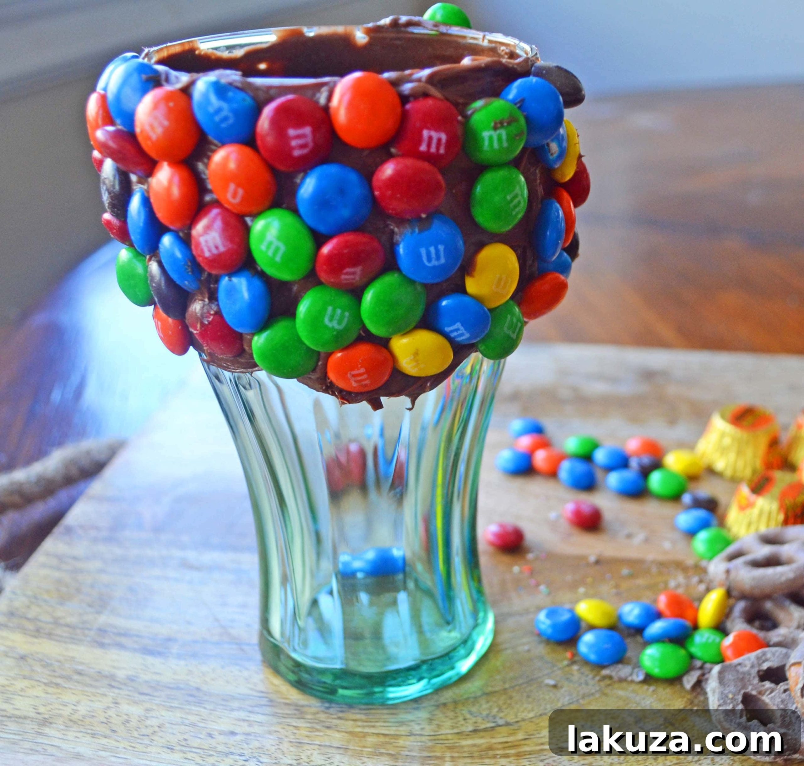 Recreate Black Tap's Jaw-Dropping Milkshakes 5 Decorated glass for a Black Tap copycat milkshake, featuring an array of colorful candies and treats pressed into a frosting rim, ready to be chilled before adding the shake.