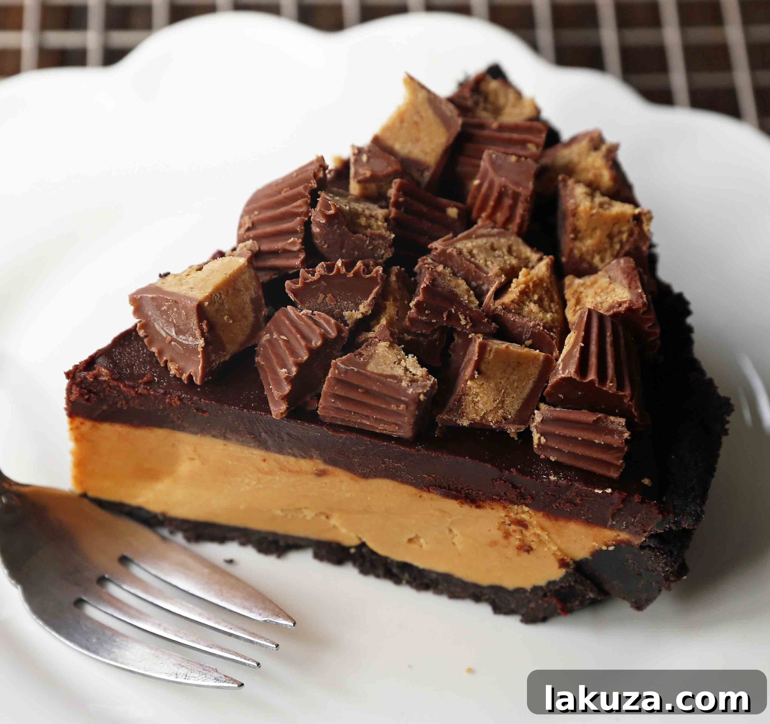 Homemade chocolate peanut butter pie with an OREO cookie crust, creamy peanut butter mousse filling, topped with chocolate ganache and Reese's peanut butter cups. A perfect dessert for chocolate and peanut butter lovers.