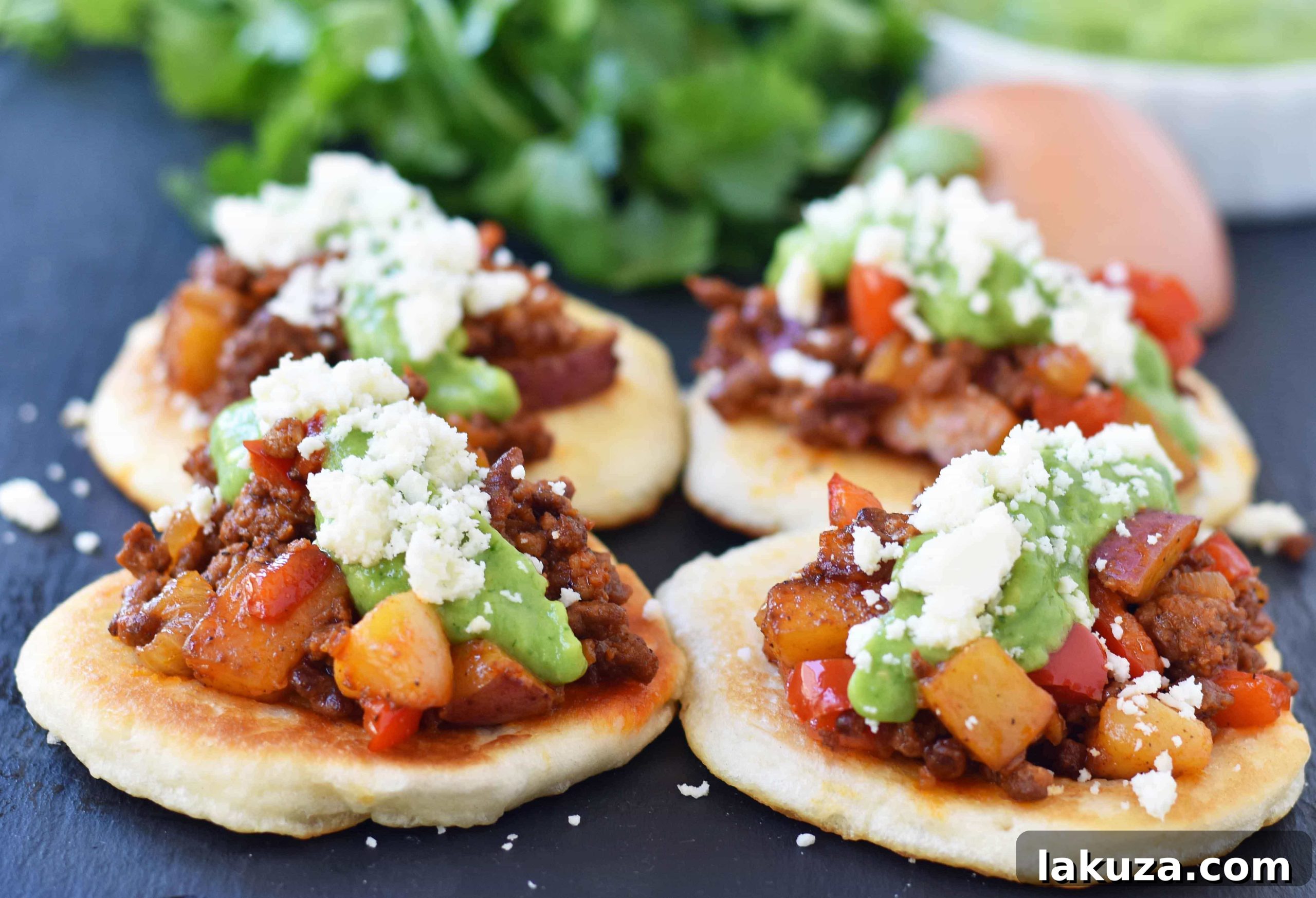 Close-up view of a single Chorizo Potato Puffy Taco, highlighting its fluffy texture, savory filling, and fresh toppings, created by Melissa Stadler.