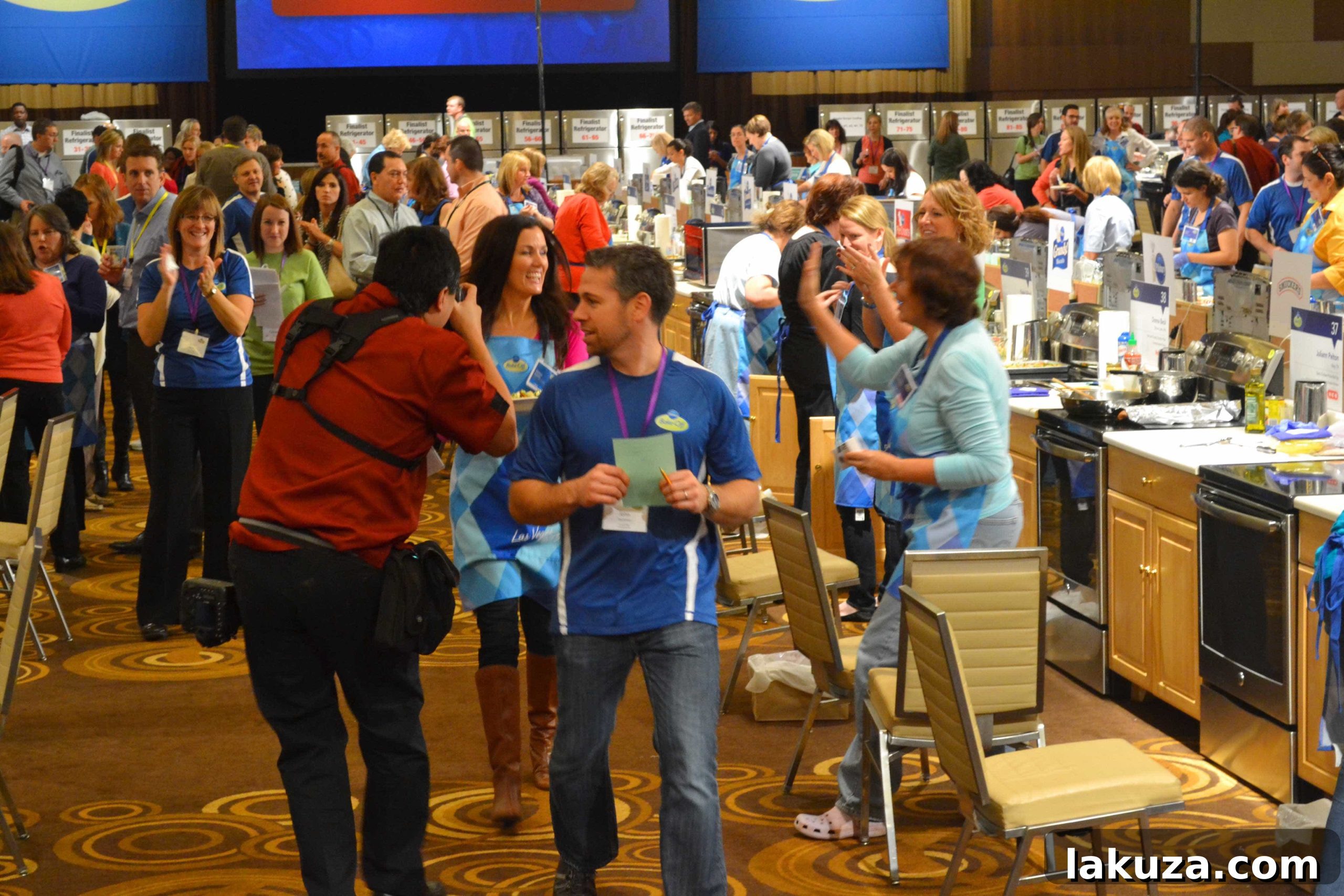 A wide shot capturing the vibrant atmosphere of the 46th Pillsbury Bake-Off Contest in Las Vegas, 2013, with Melissa Stadler working on her Chorizo Potato Puffy Tacos.