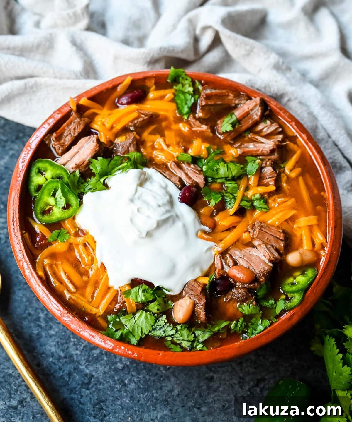 A vibrant array of chili toppings, including cheese, sour cream, cilantro, and avocado.