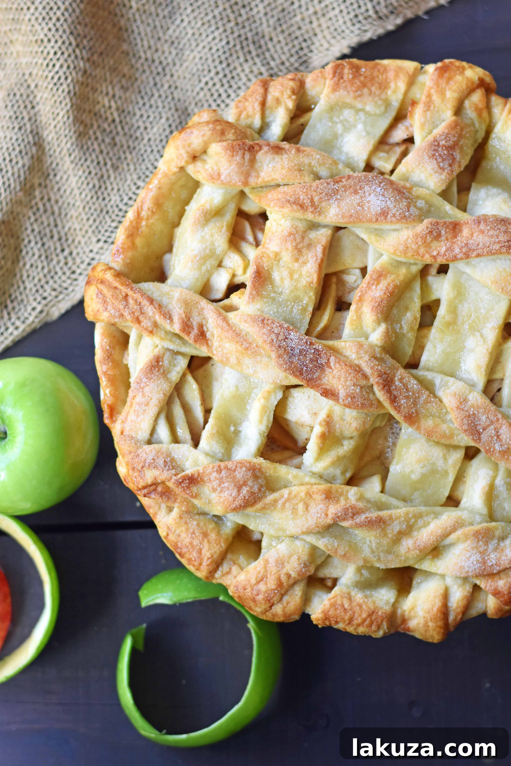 Close-up of a slice of salted caramel apple pie, revealing layers of tender apples and gooey caramel under a delicate lattice crust, ready to be enjoyed.