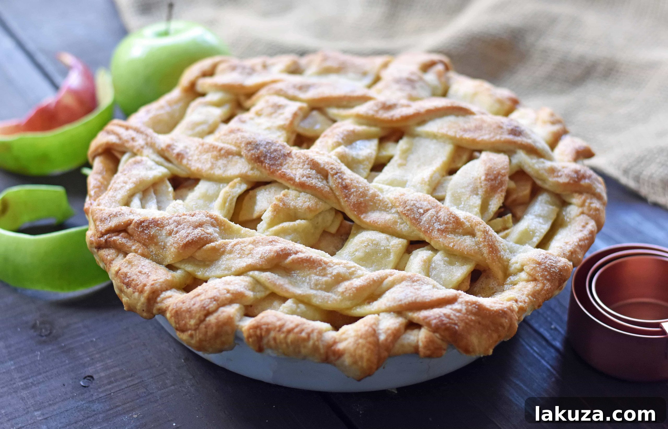 Individual serving of salted caramel apple pie, topped with melting vanilla ice cream and an extra drizzle of caramel, showcasing its decadent presentation.