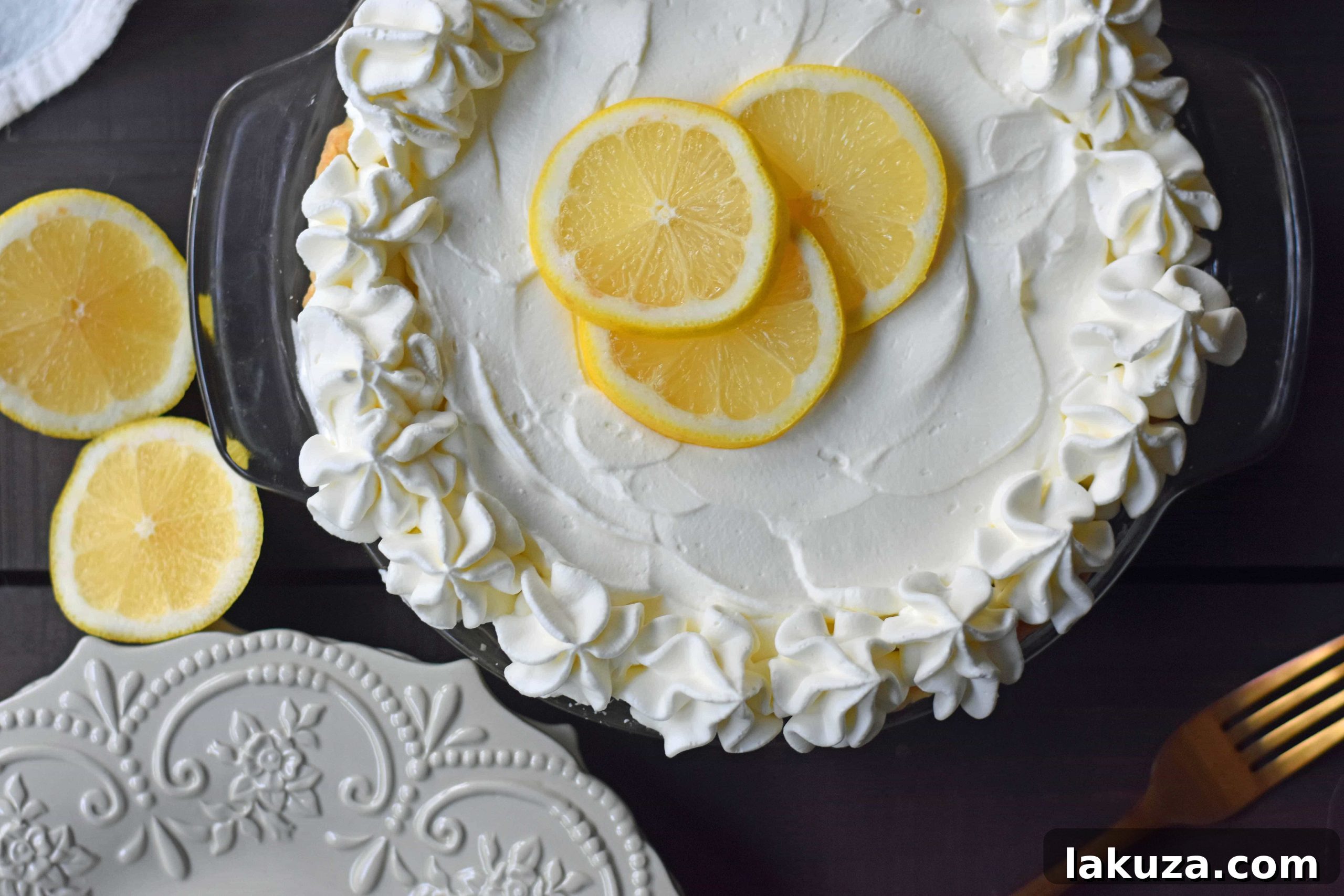 A beautifully garnished Sweet Lemon Sour Cream Pie, topped with elegant swirls of whipped cream and delicate lemon zest