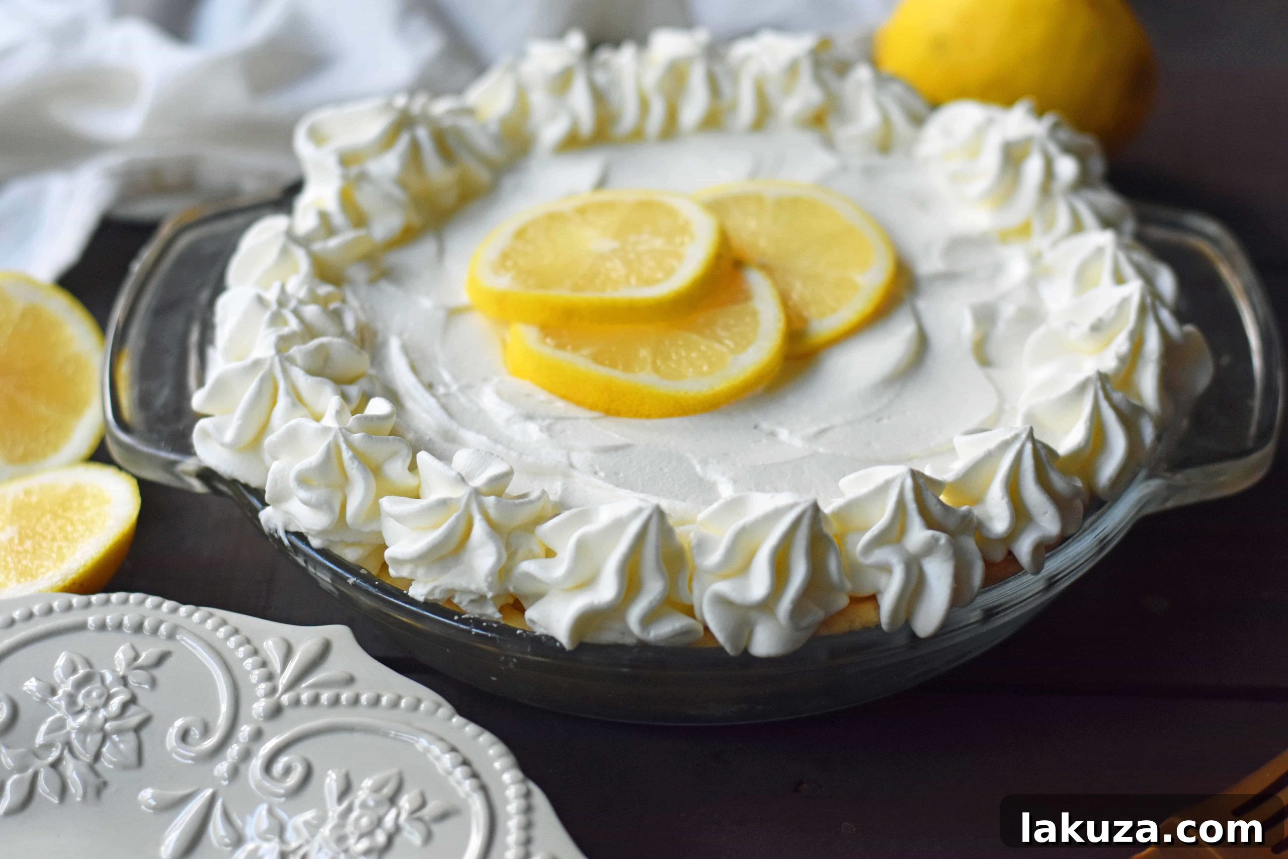 A top-down view of a Sweet Lemon Sour Cream Pie, showcasing the whipped cream topping and a hint of the lemon filling