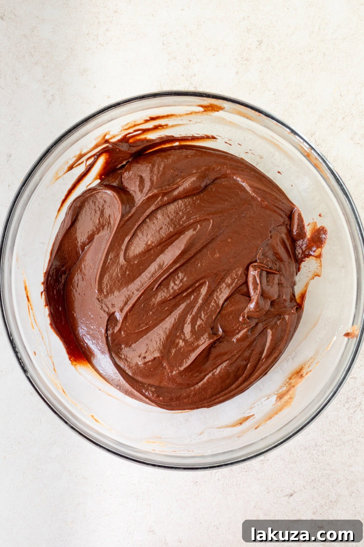 Silky smooth chocolate cream pie filling poured into a bowl after cooking.