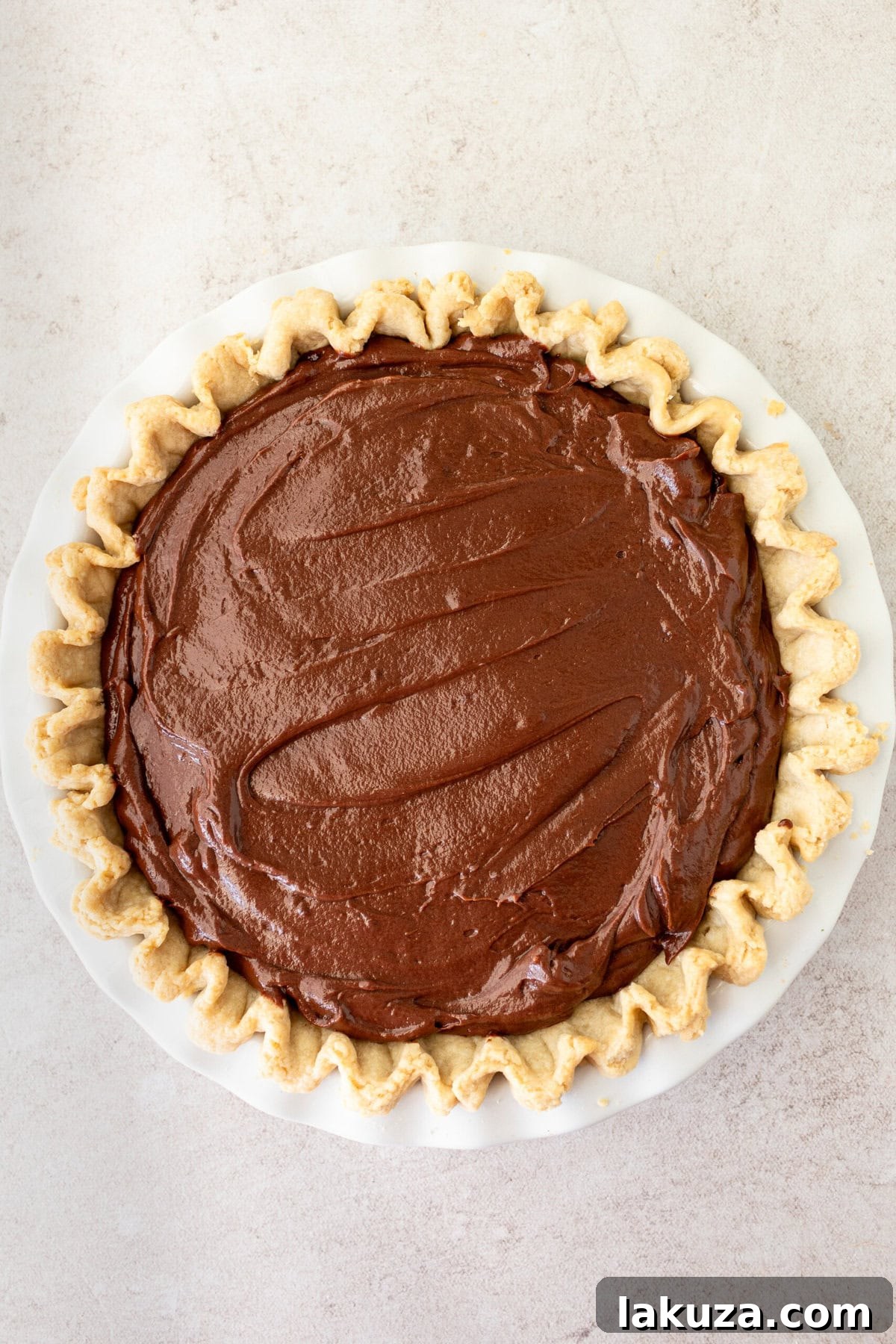 Chocolate Cream Pie filling smoothly spread into a pre-baked pie crust.