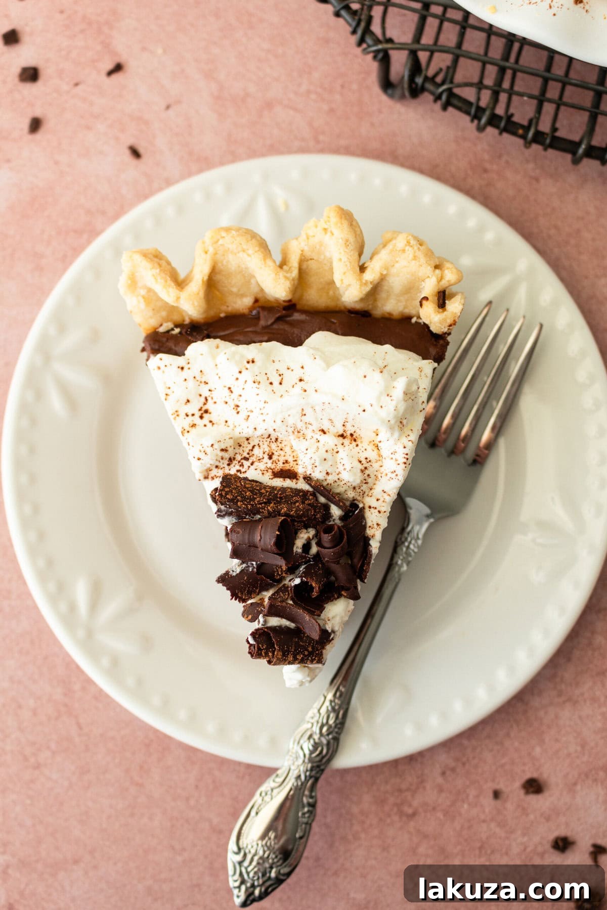 A large slice of Chocolate Cream Pie on a white plate, ready to be enjoyed.