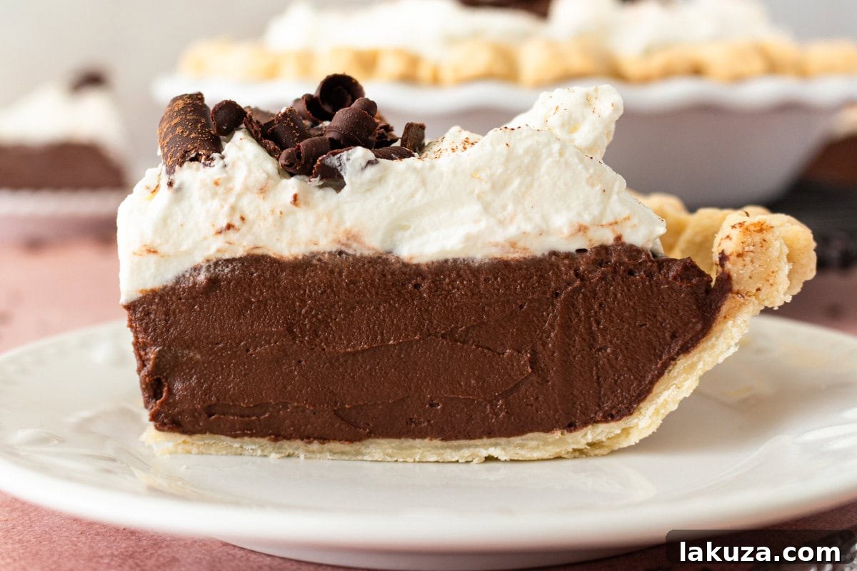 An elegantly styled Chocolate Cream Pie with a single slice removed, ready for serving.