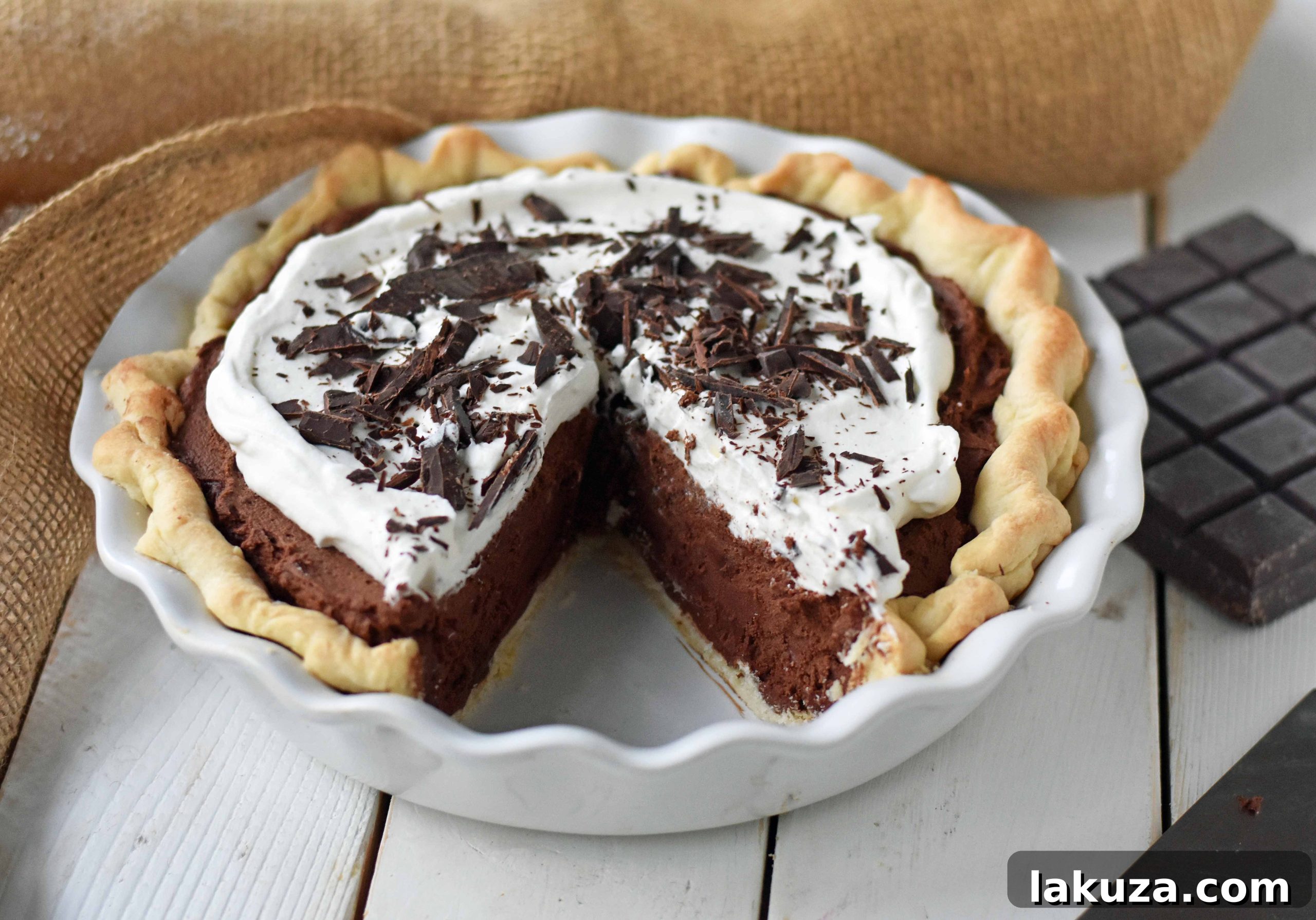 Close-up of a full Chocolate Cream Pie with generous whipped cream and chocolate shavings.