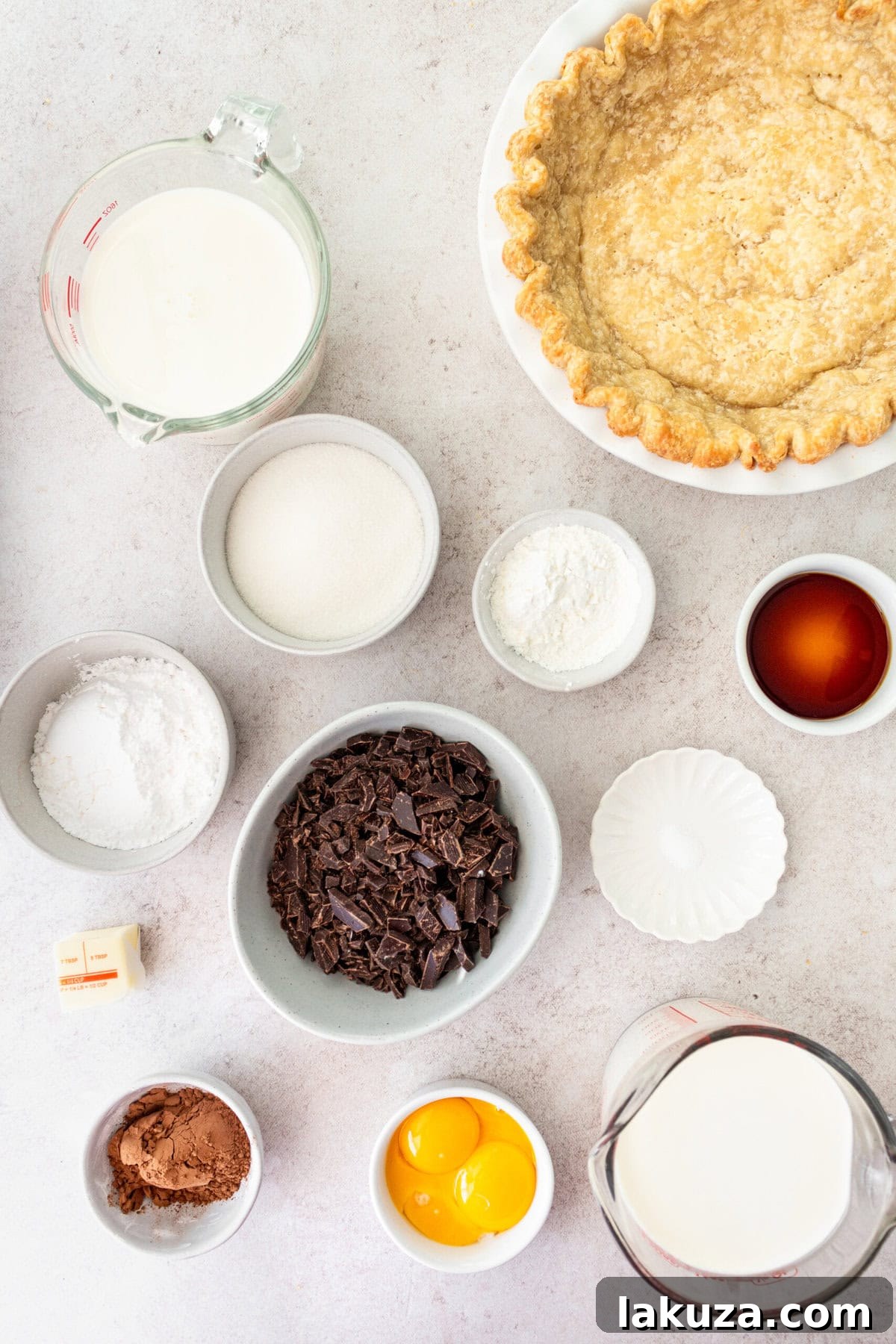 Ingredients laid out for Chocolate Cream Pie, including chocolate bars, sugar, butter, vanilla, cocoa, cornstarch, milk, and cream.