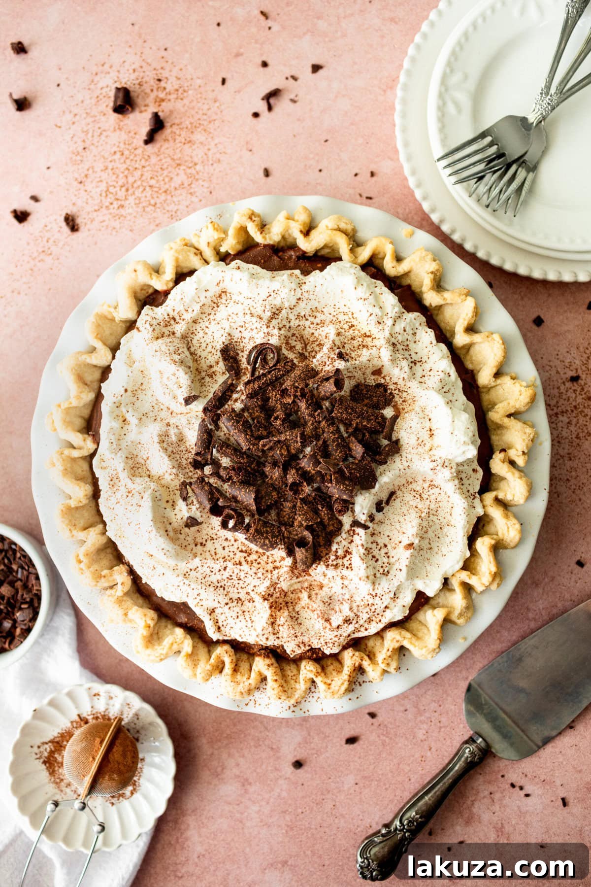 A beautifully presented slice of Chocolate Cream Pie, showcasing the smooth chocolate filling, crisp crust, and generous whipped cream topping.