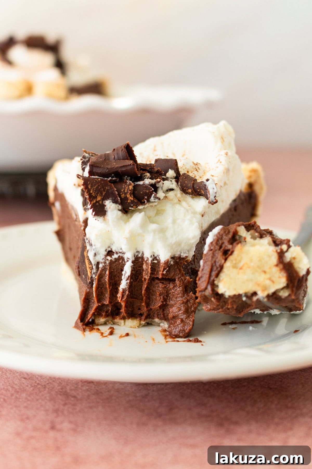 Close-up of a full Chocolate Cream Pie, showcasing the texture of the crust, filling, and whipped topping with chocolate curls.
