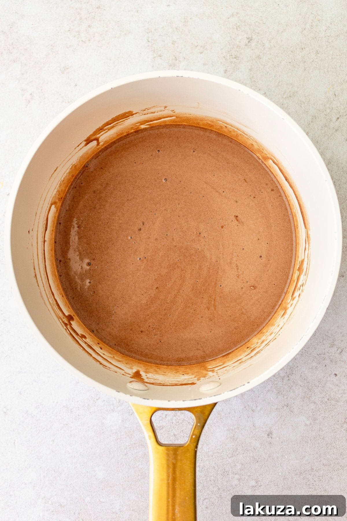 Process shot of whisking chocolate cream pie filling in a saucepan.