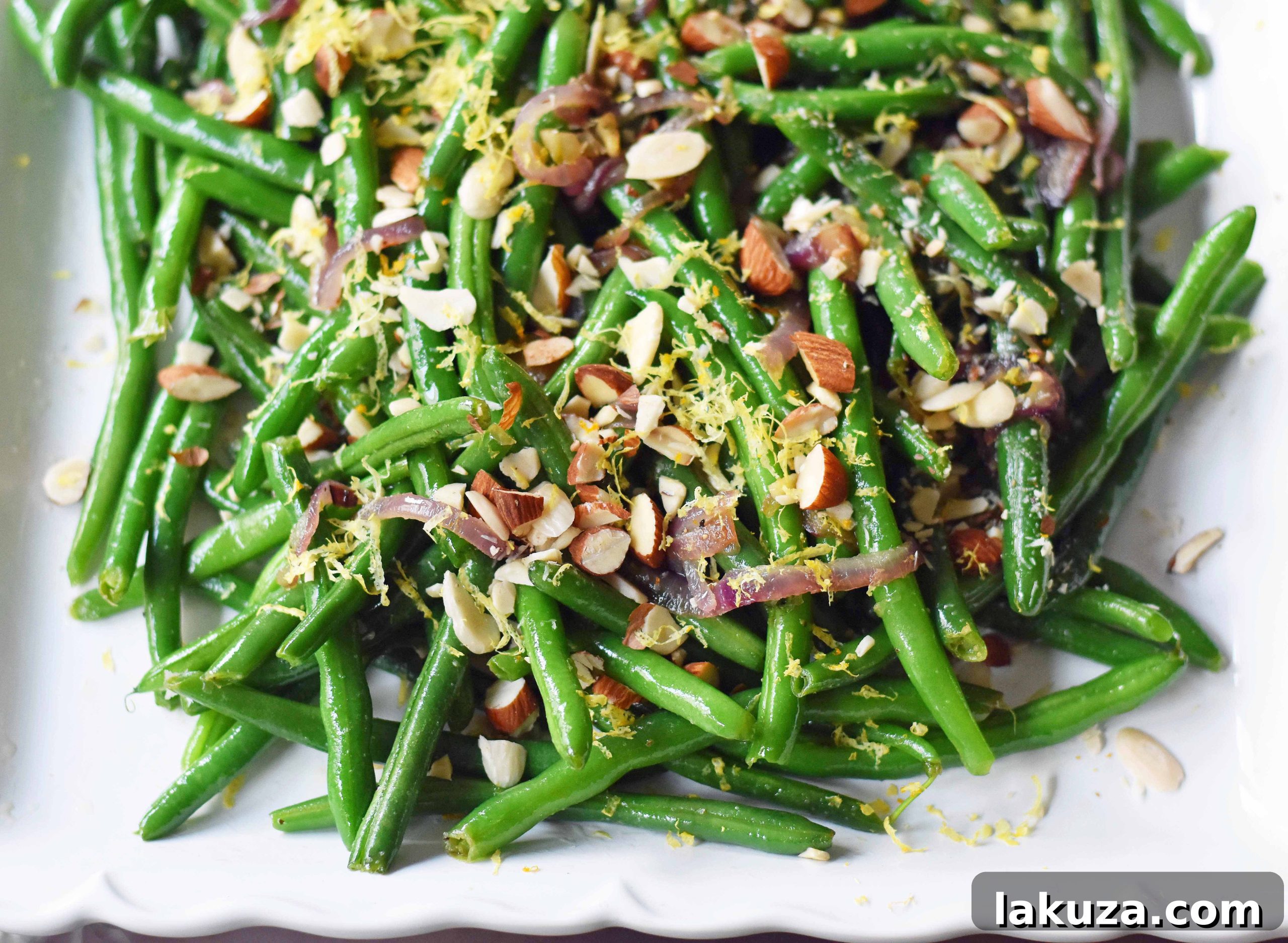 Close-up of Green Beans Almondine featuring beautifully caramelized onions, bright lemon zest, and perfectly toasted almonds, showcasing the delicious textures and colors of this healthy side dish.