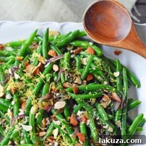 Green Beans Almondine with Caramelized Onions, Lemon Zest, and Toasted Almonds – a light, fresh, and perfectly seasoned side dish. Modern Honey Recipe.