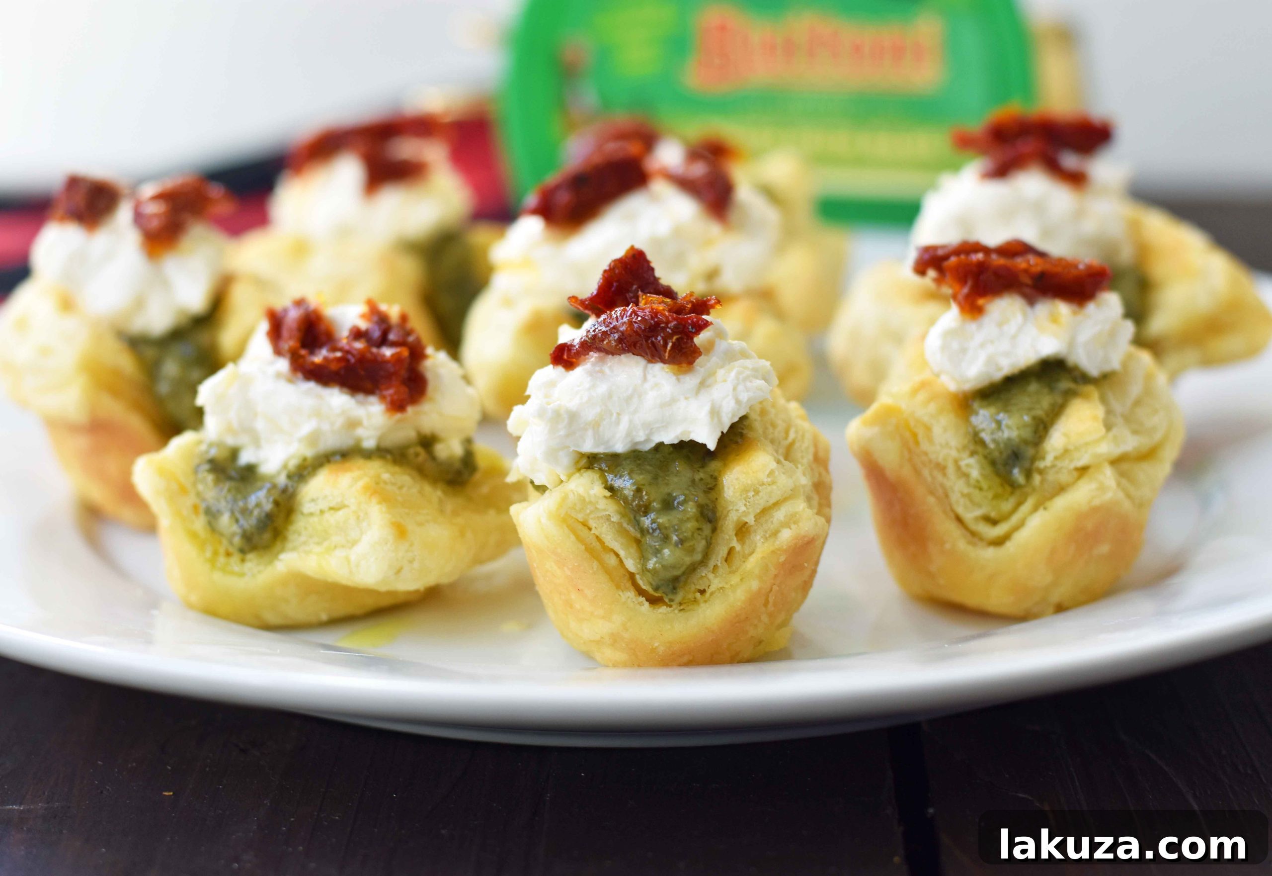 Pesto Parmesan Sundried Tomato Tartlets feature golden puff pastry, fresh Buitoni pesto, creamy cheese, and sweet sun-dried tomatoes.