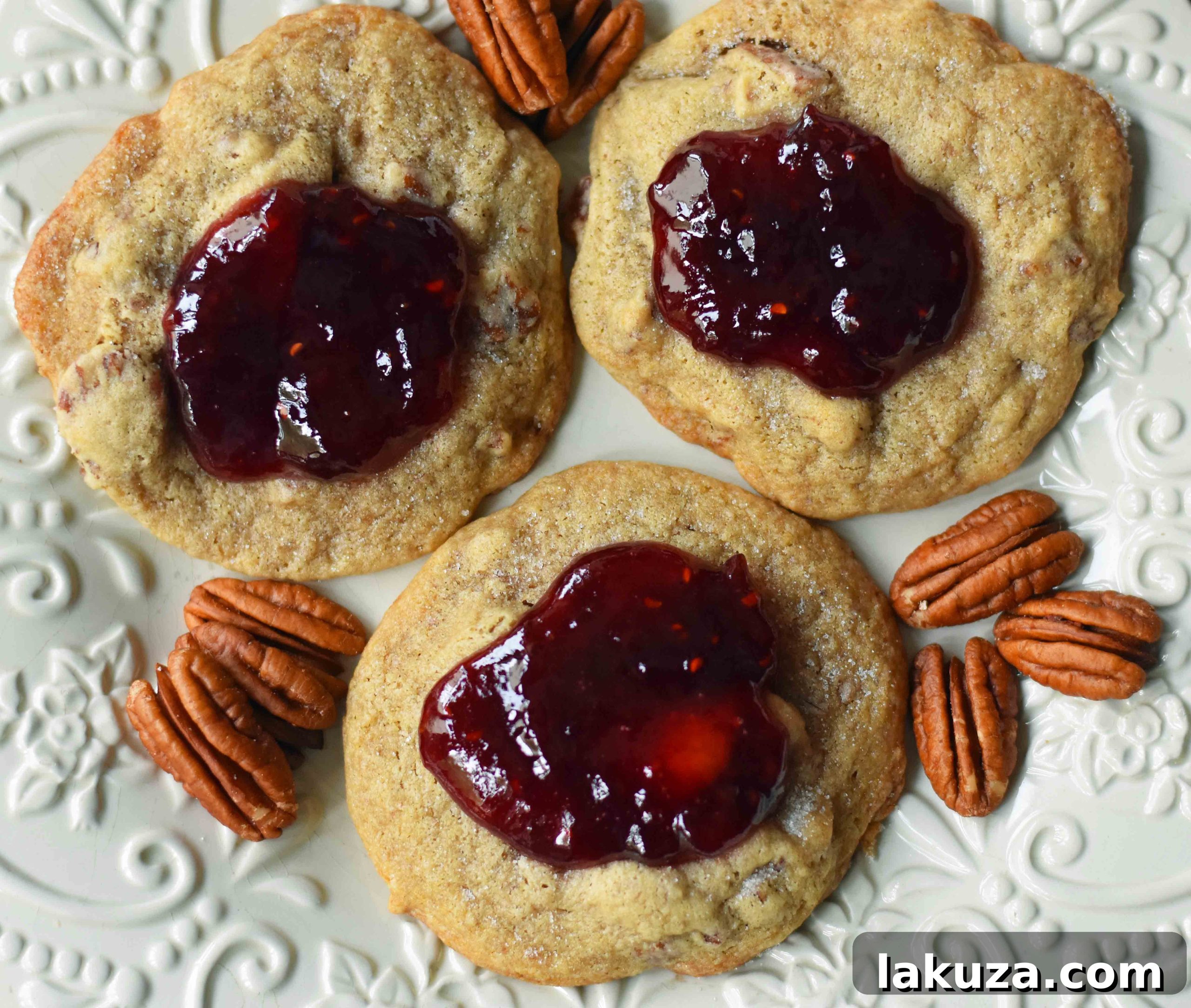 Soft and chewy Cream Cheese Pecan Jam Thumbprint Cookies topped with vibrant fresh jam.