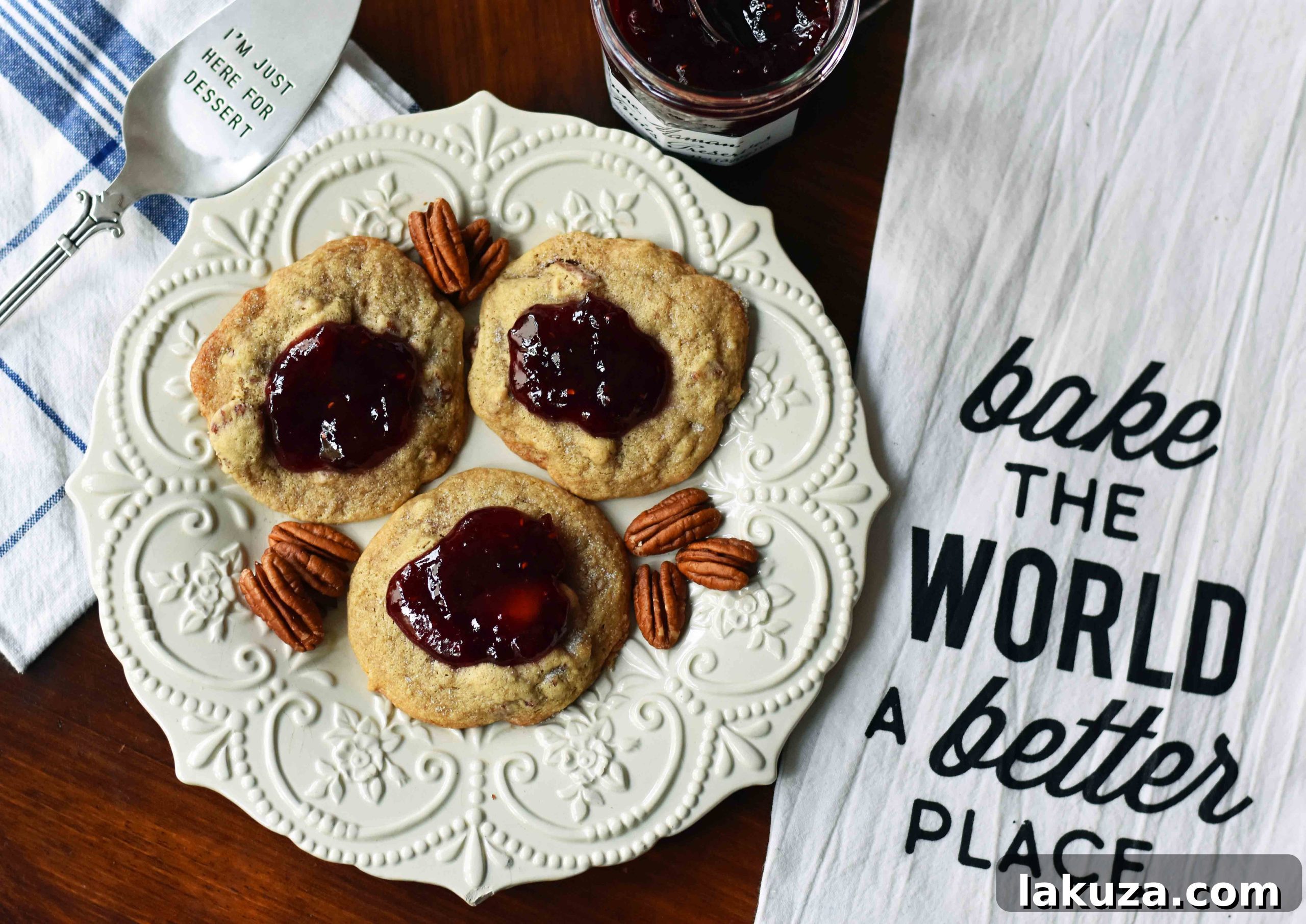 Close-up of Cream Cheese Pecan Jam Thumbprint Cookies with a dollop of fresh jam.