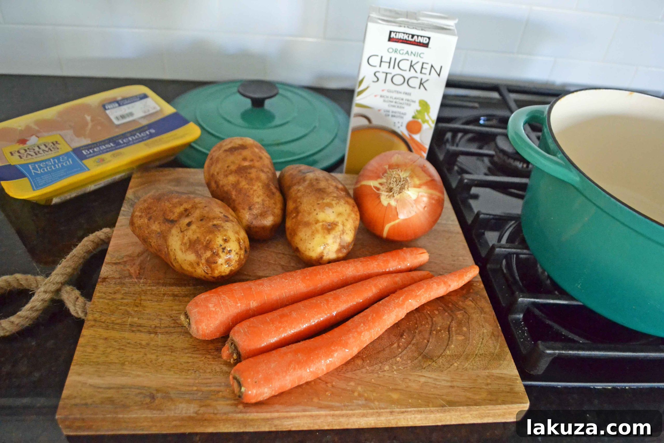 Close-up of fresh ingredients for homemade chicken soup, including diced onion, garlic, carrots, potatoes, and herbs.