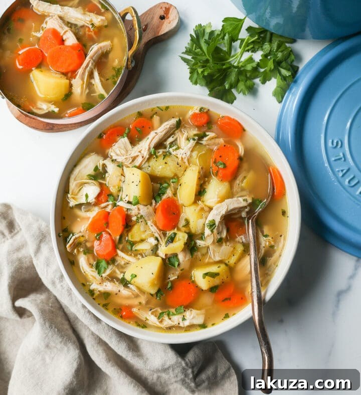 A bowl of hot homemade chicken soup with a slice of bread on the side, emphasizing comfort and warmth.