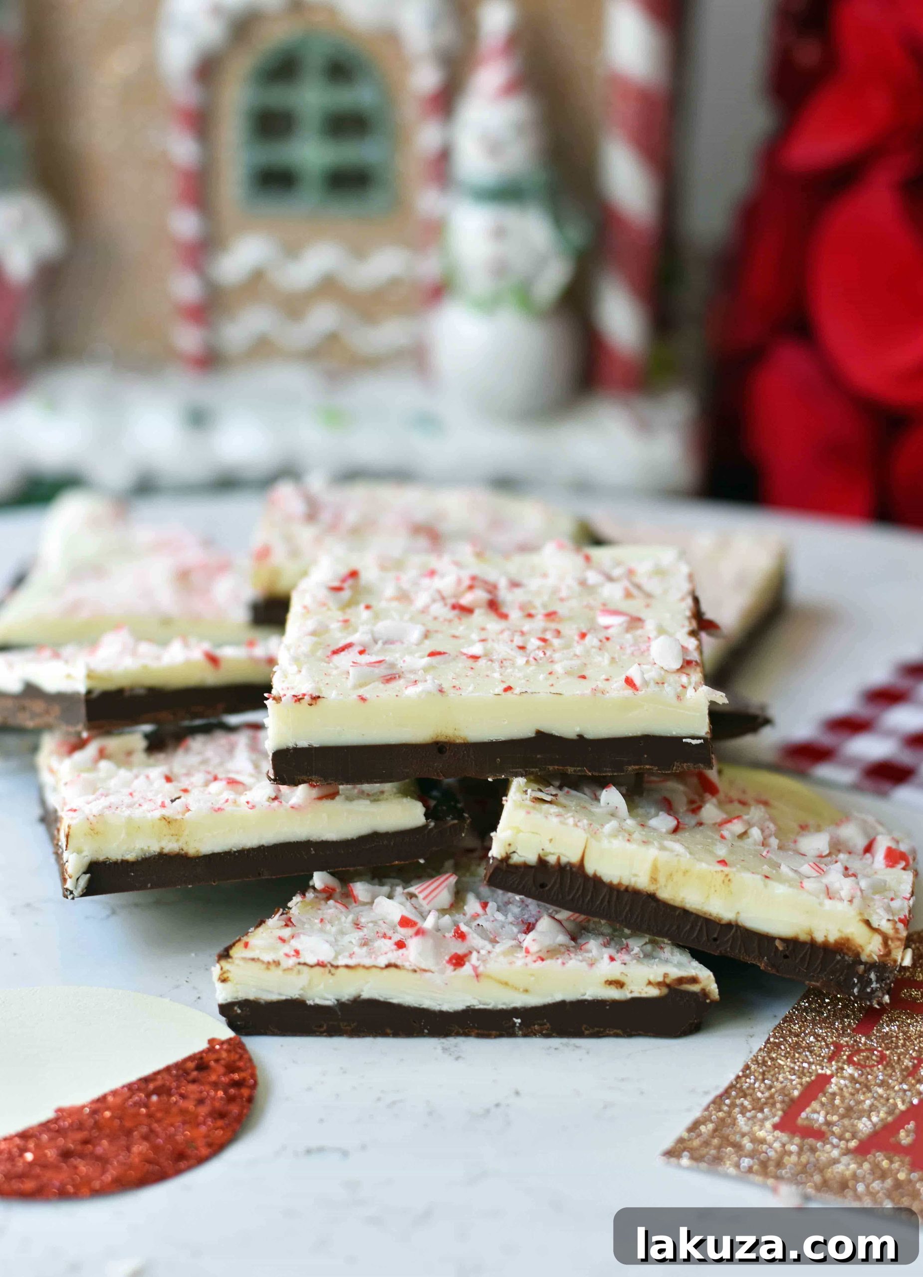 Wintermint Chocolate Crunch 3 Close-up of a festive slice of Chocolate Peppermint Bark showcasing its distinct layers of dark and white chocolate, generously sprinkled with bright red and white crushed peppermint candy canes, ready for sharing.