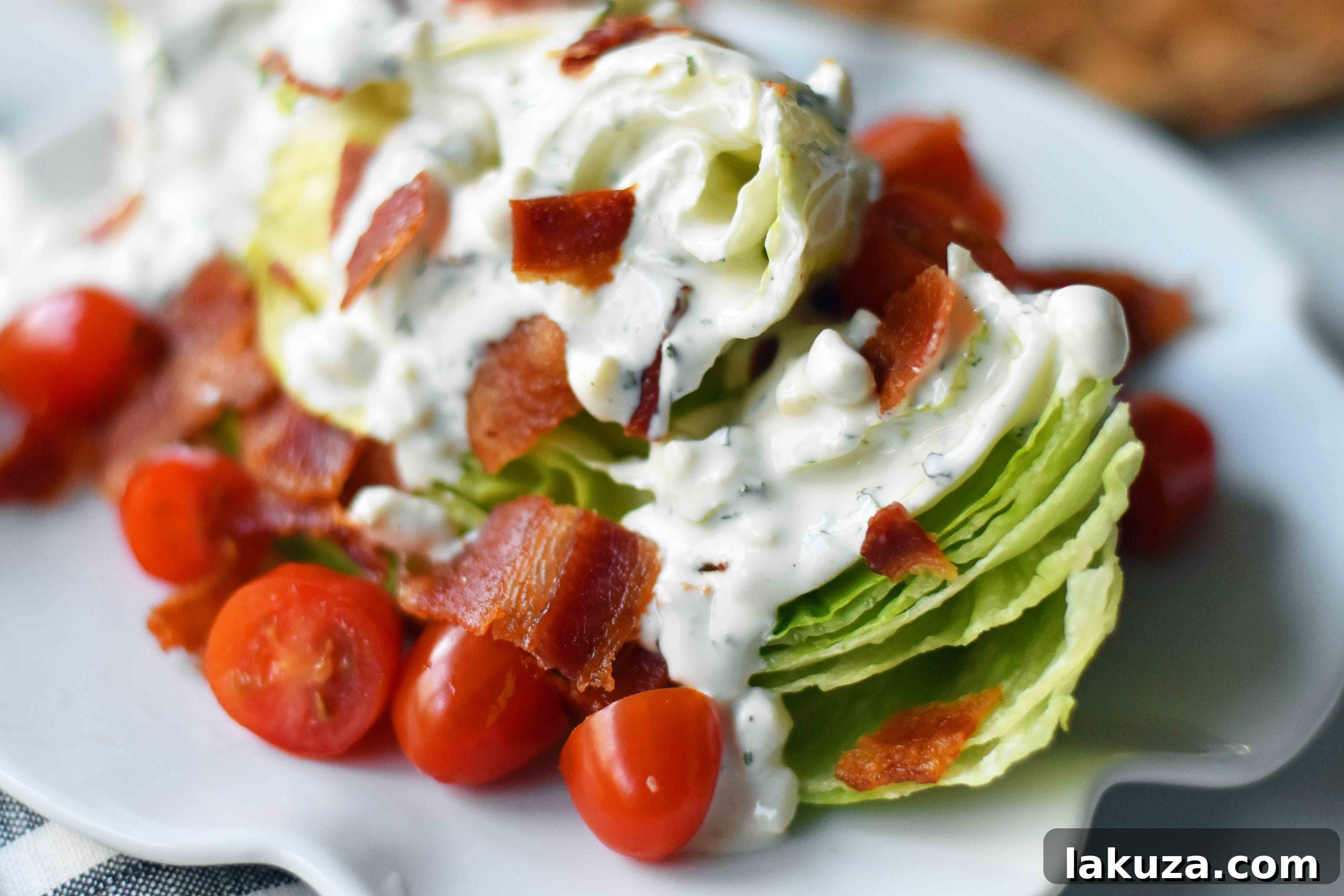 Iconic BLT Wedge 4 Closeup of the Ultimate BLT Wedge Salad showcasing crunchy iceberg, juicy tomatoes, crispy bacon, and luscious dressing with a hint of balsamic glaze.