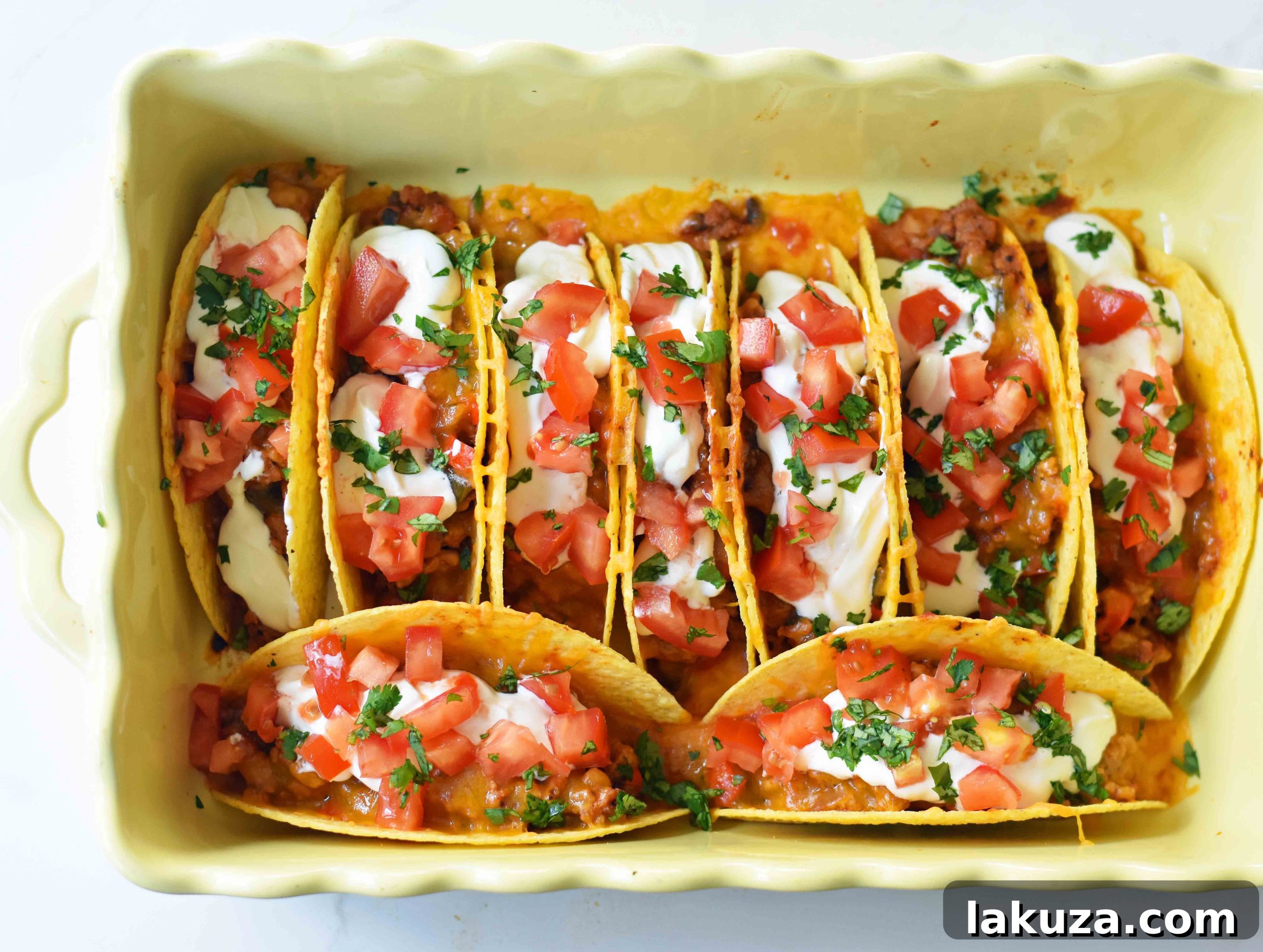 Close-up of golden brown oven-baked beef tacos with rich ground beef filling and bubbling cheese.
