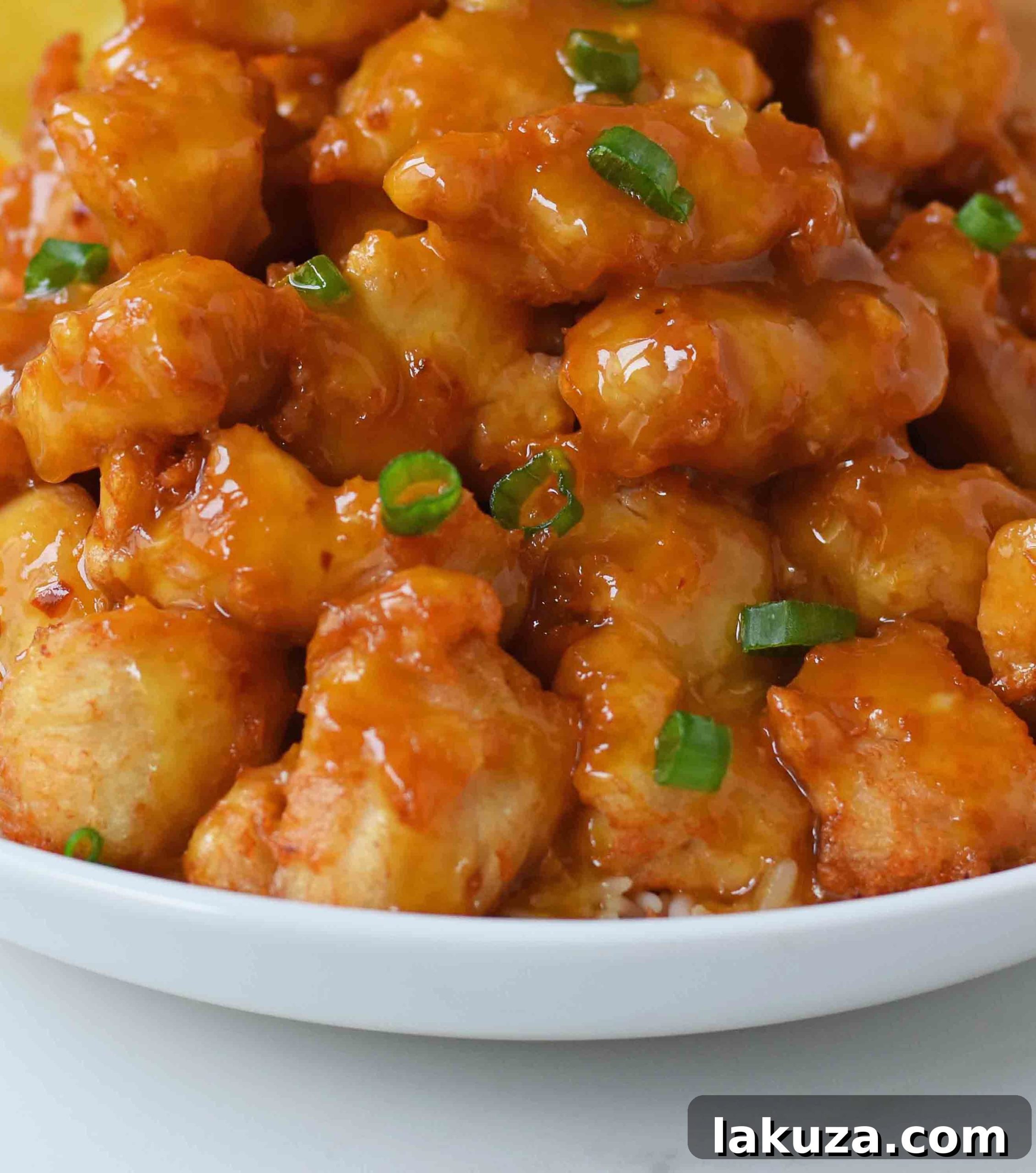 A bowl of fresh oranges, green onions, and ginger, key ingredients for homemade orange chicken.