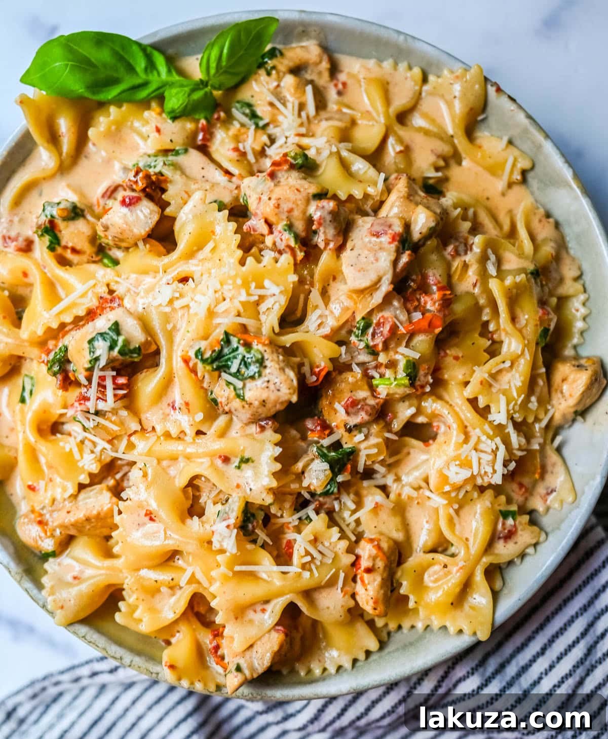 Ingredients for Marry Me Chicken Pasta laid out on a kitchen counter, highlighting fresh produce and key components.