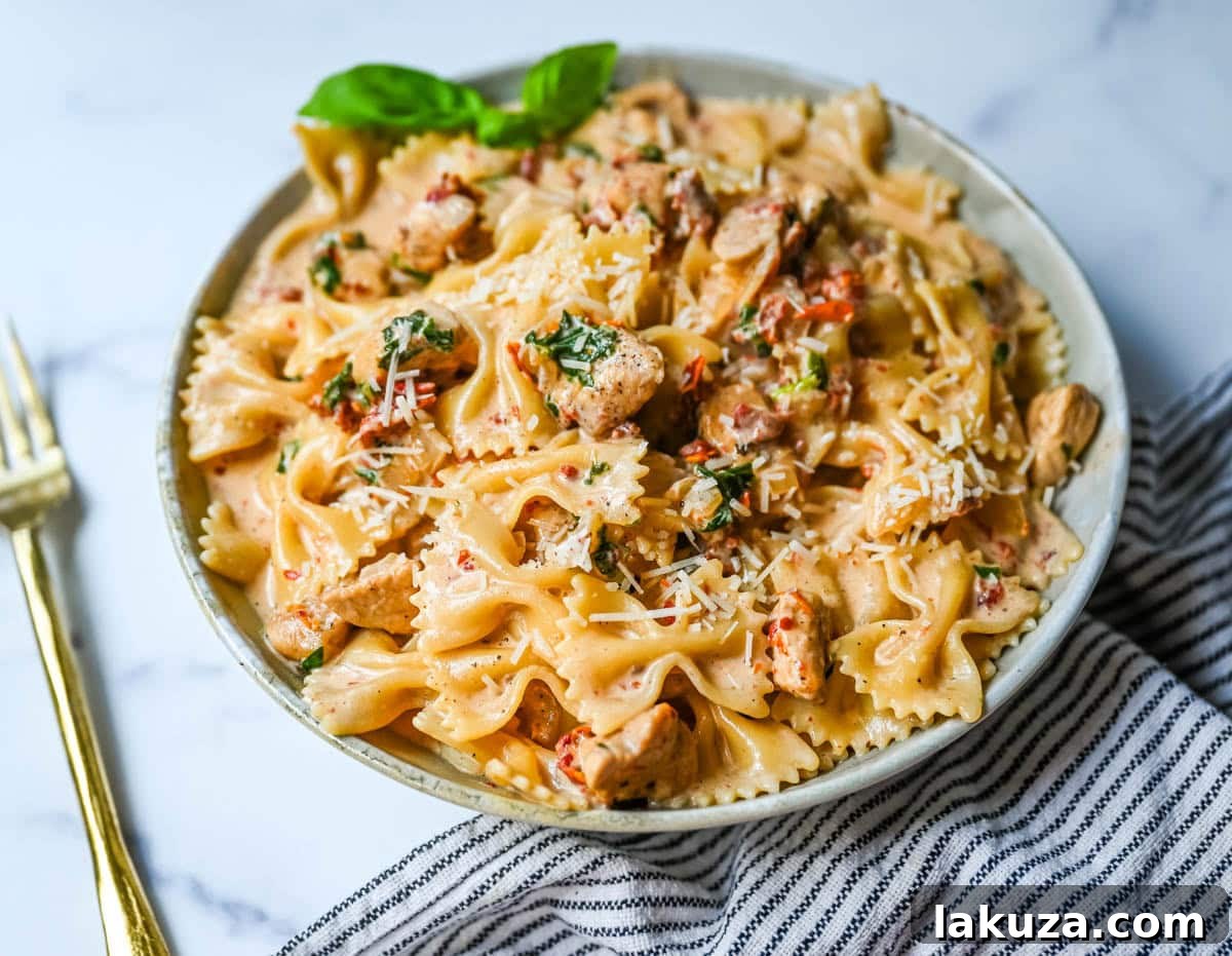A serving of Marry Me Chicken Pasta in a bowl, garnished with fresh basil leaves, ready to be enjoyed.