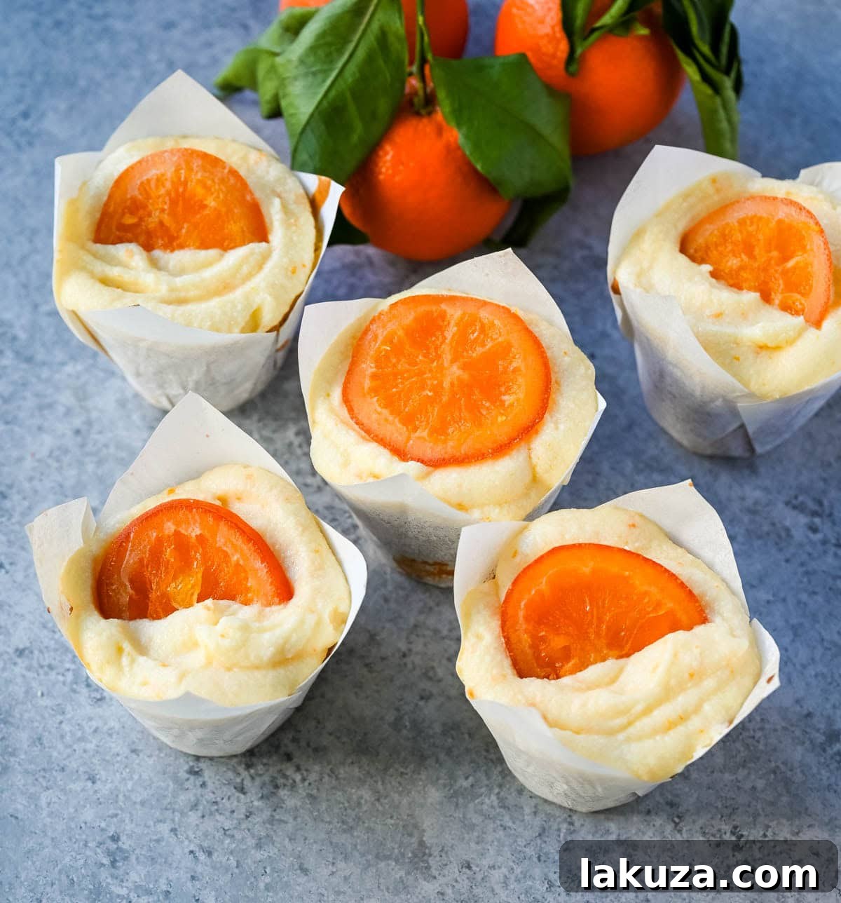 Sun-Kissed Orange Olive Oil Delights 4 Close-up of moist orange olive oil cupcakes with swirls of orange cream cheese frosting, ready to be served.